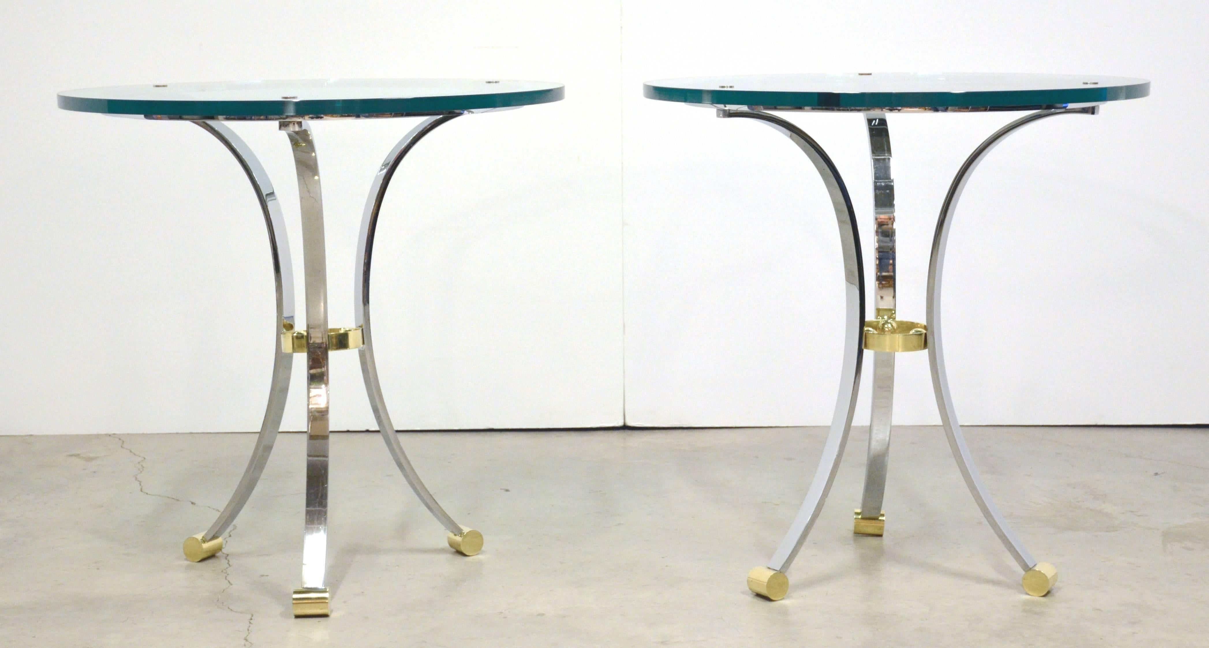 Pair of three-legged chromed steel side or end tables with brass accents and glass tops. Uniquely fine condition of polished chrome and brass with 3/4