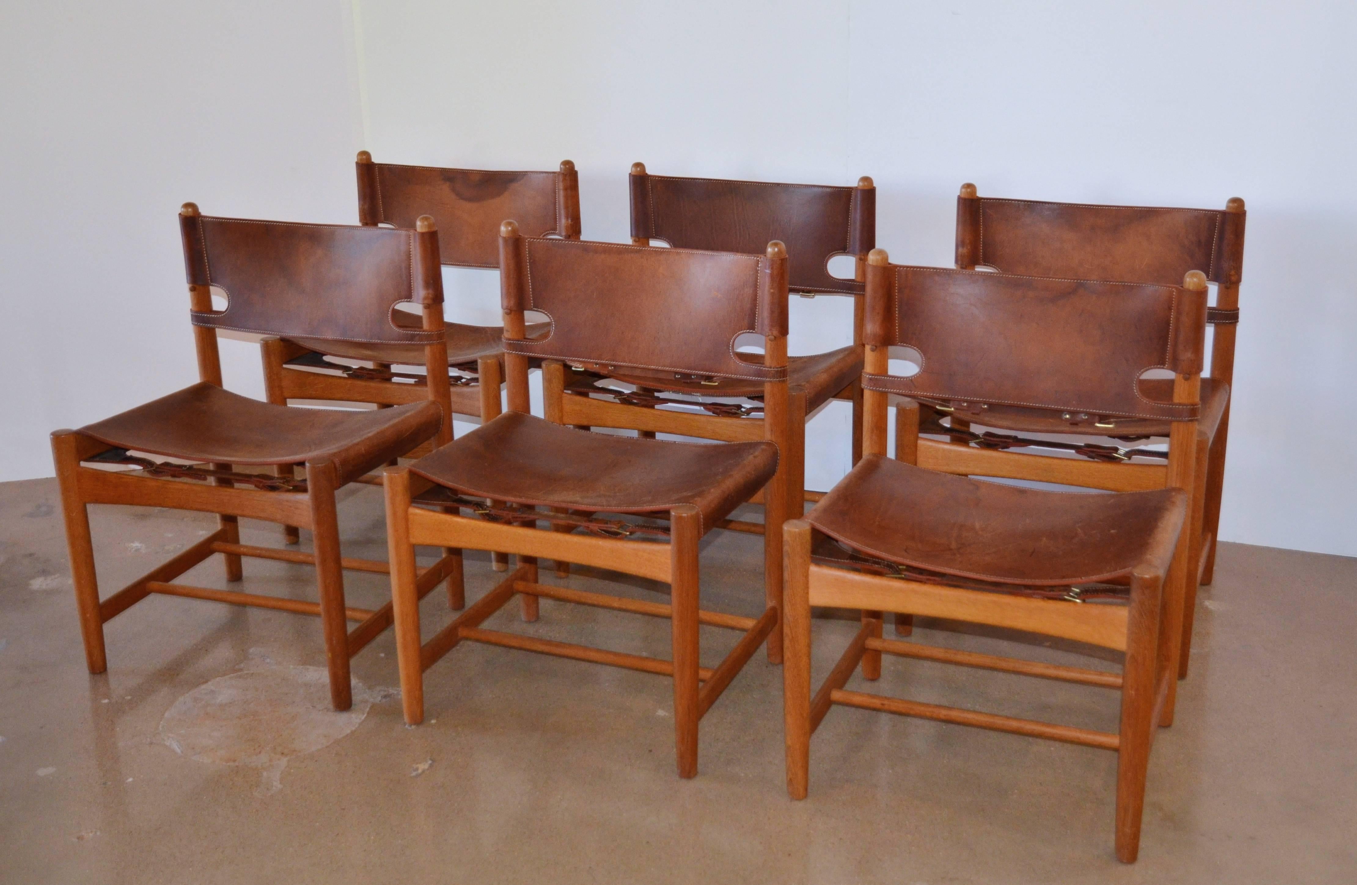 Hard to find pair (three pairs available) of Børge Mogensen hunting chairs Model 3237. Produced by Fredericia furniture with partial labels remaining on two of the six chairs, see photographs. Oak frames have original saddle leather backs and seats