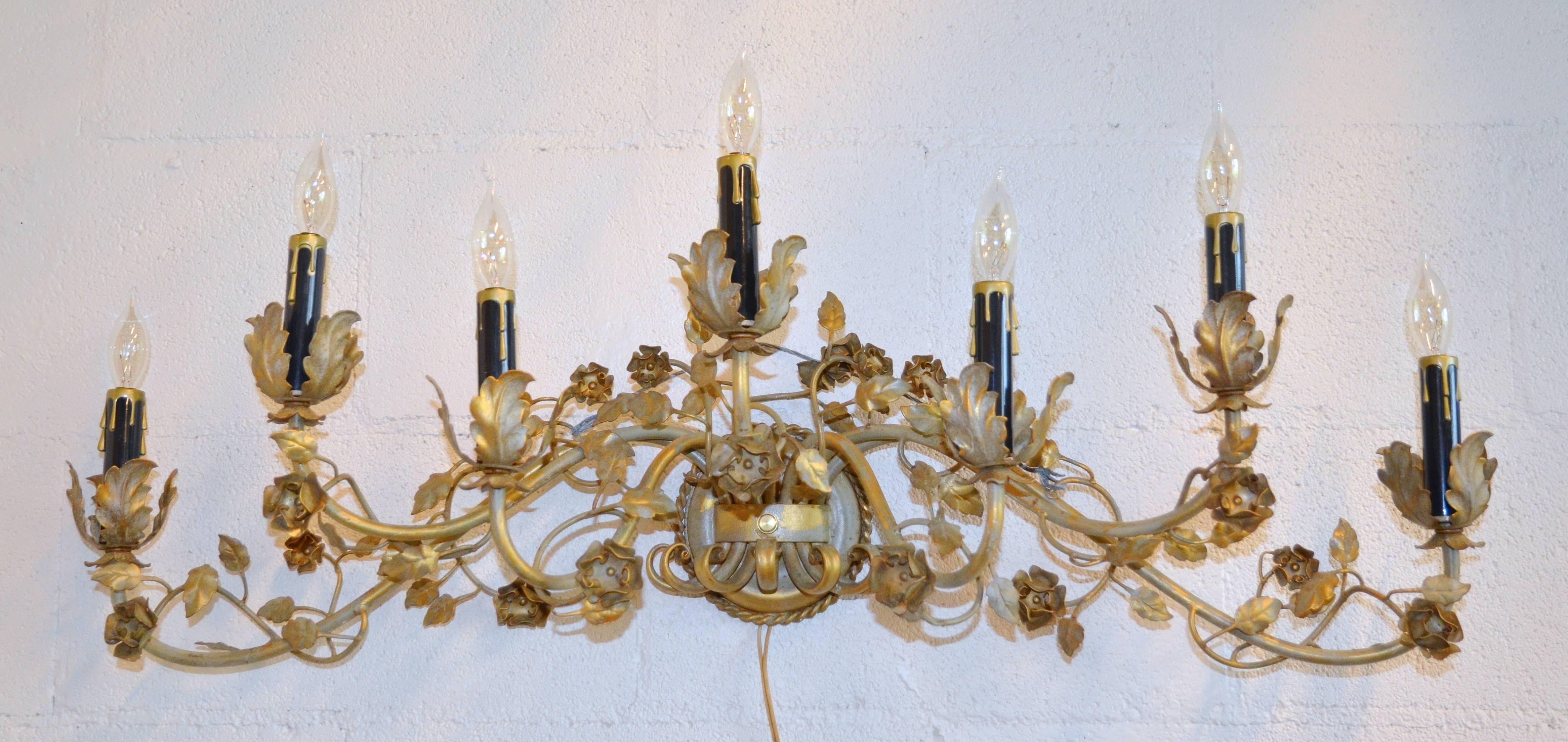 Mid-Century floral gilt sconces with black candle sheathes. This pair show great style and movement in true tole form. Measurement for height is 10