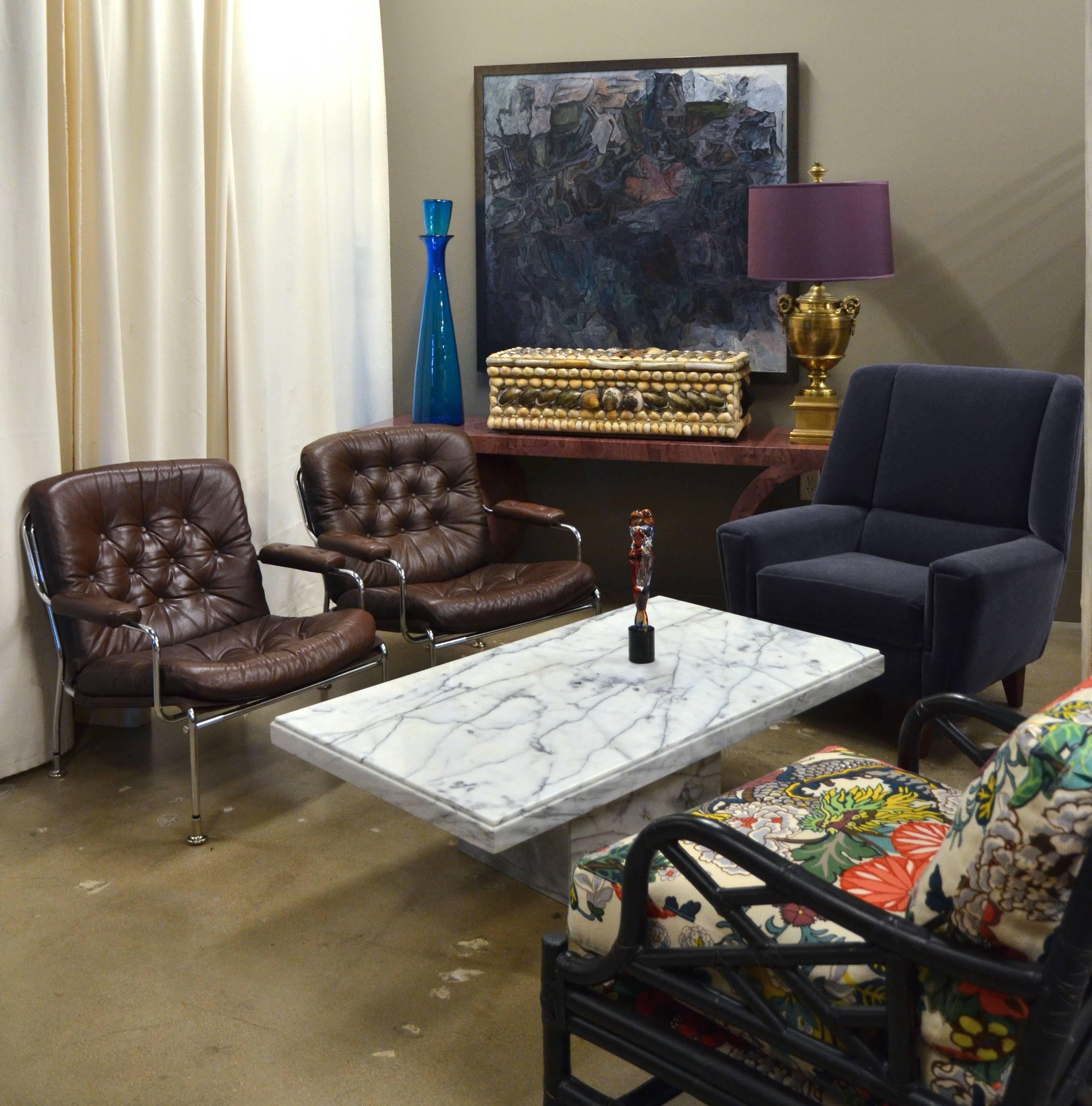 Mid-Century Modern chrome and brown leather armchairs having tufted backs and seats and chrome frames. Attributed to 'Karin' low back lounge chair by Bruno Mathsson with hard to find adjustable flat feet. Very comfortable.  Pair available, sold