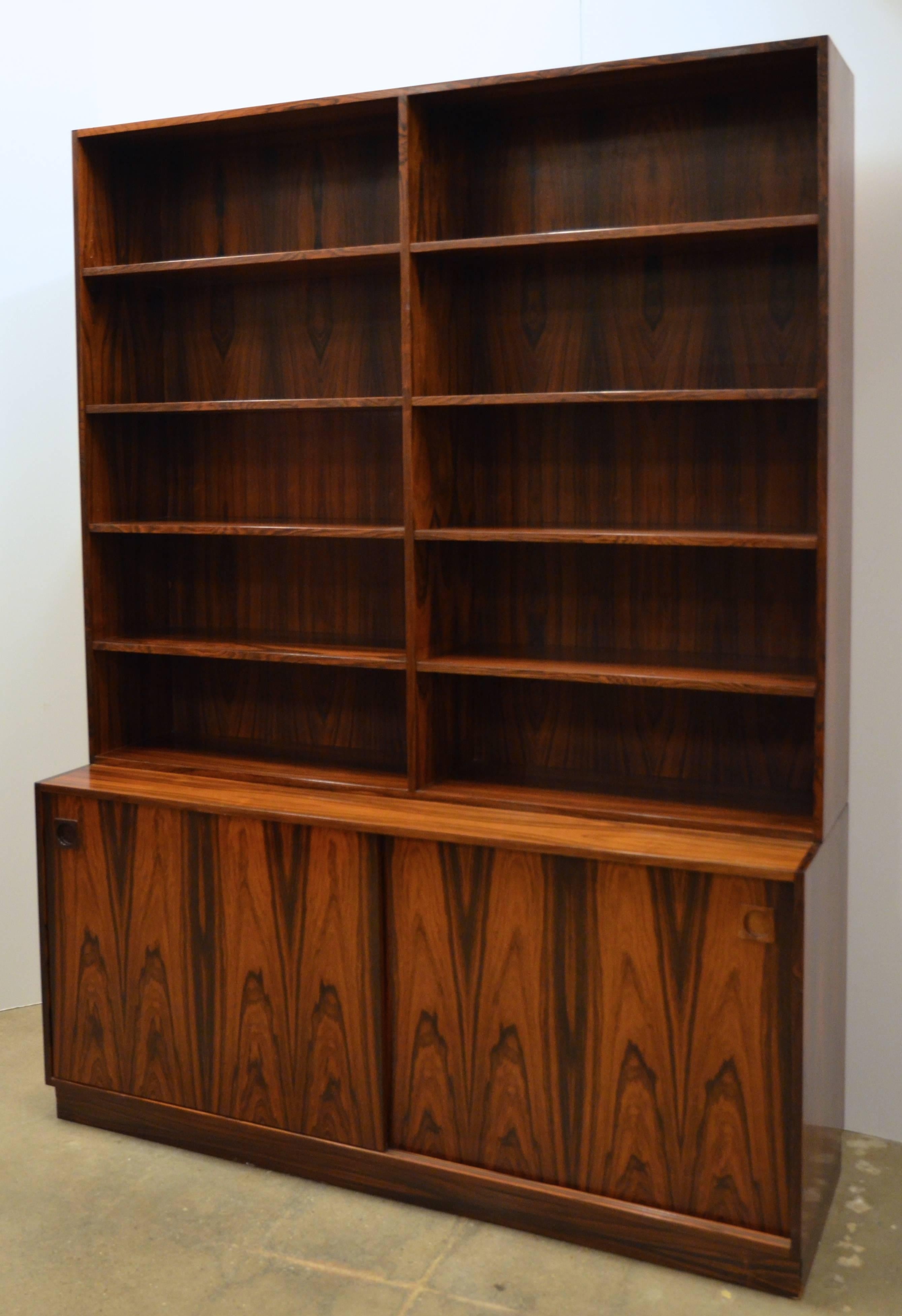 Danish Mid-Century Modern rosewood bookcase, the unit in two-sections having adjustable shelves to the upper case, the cabinet base fitted with shelving and single pull-out tray drawer.