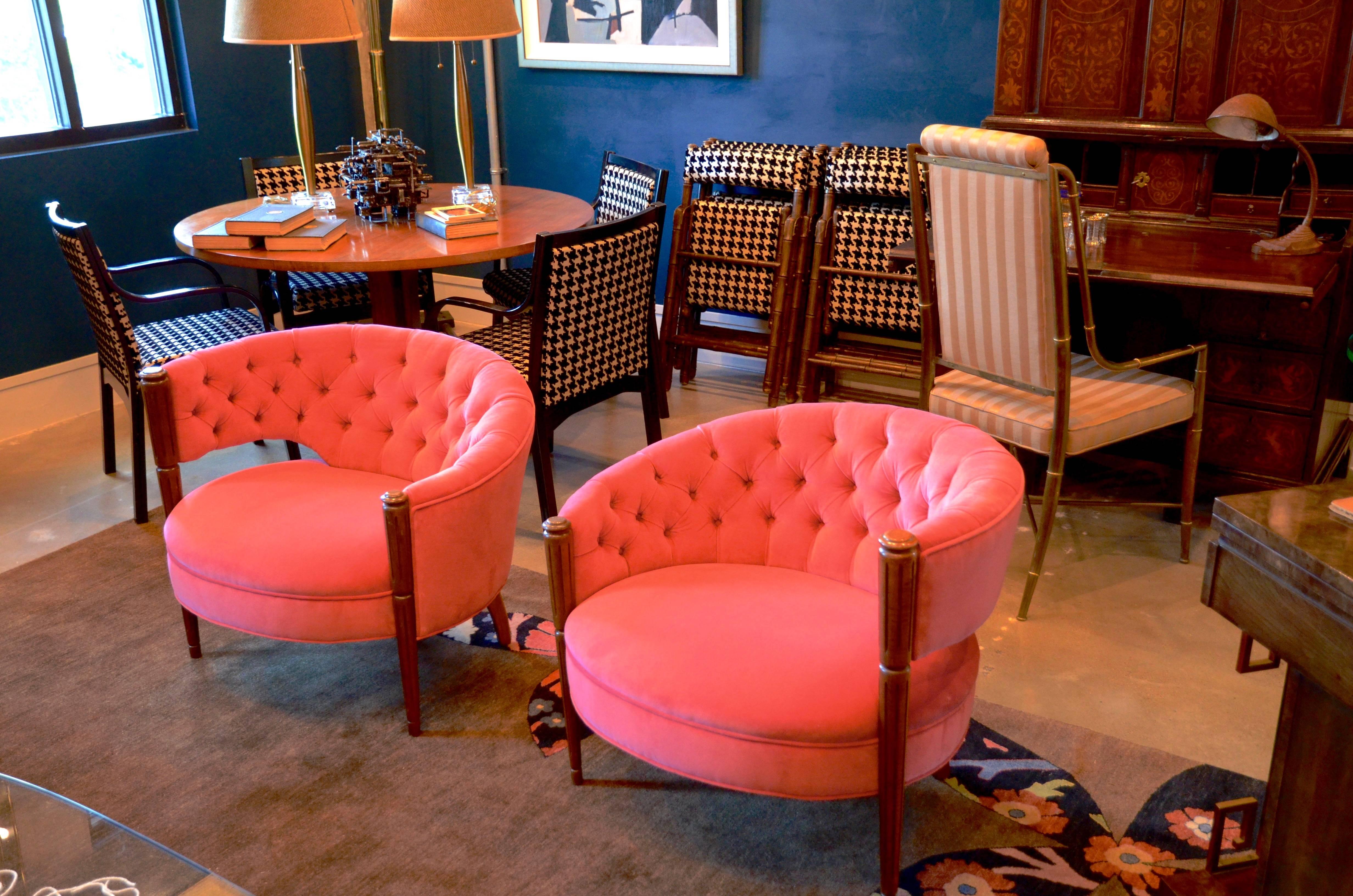 Newly upholstered in watermelon pink velvet, these round occasional chairs by J. B. Van Sciver have beautifully tufted asymmetrical barrel backs with carved and fluted legs.