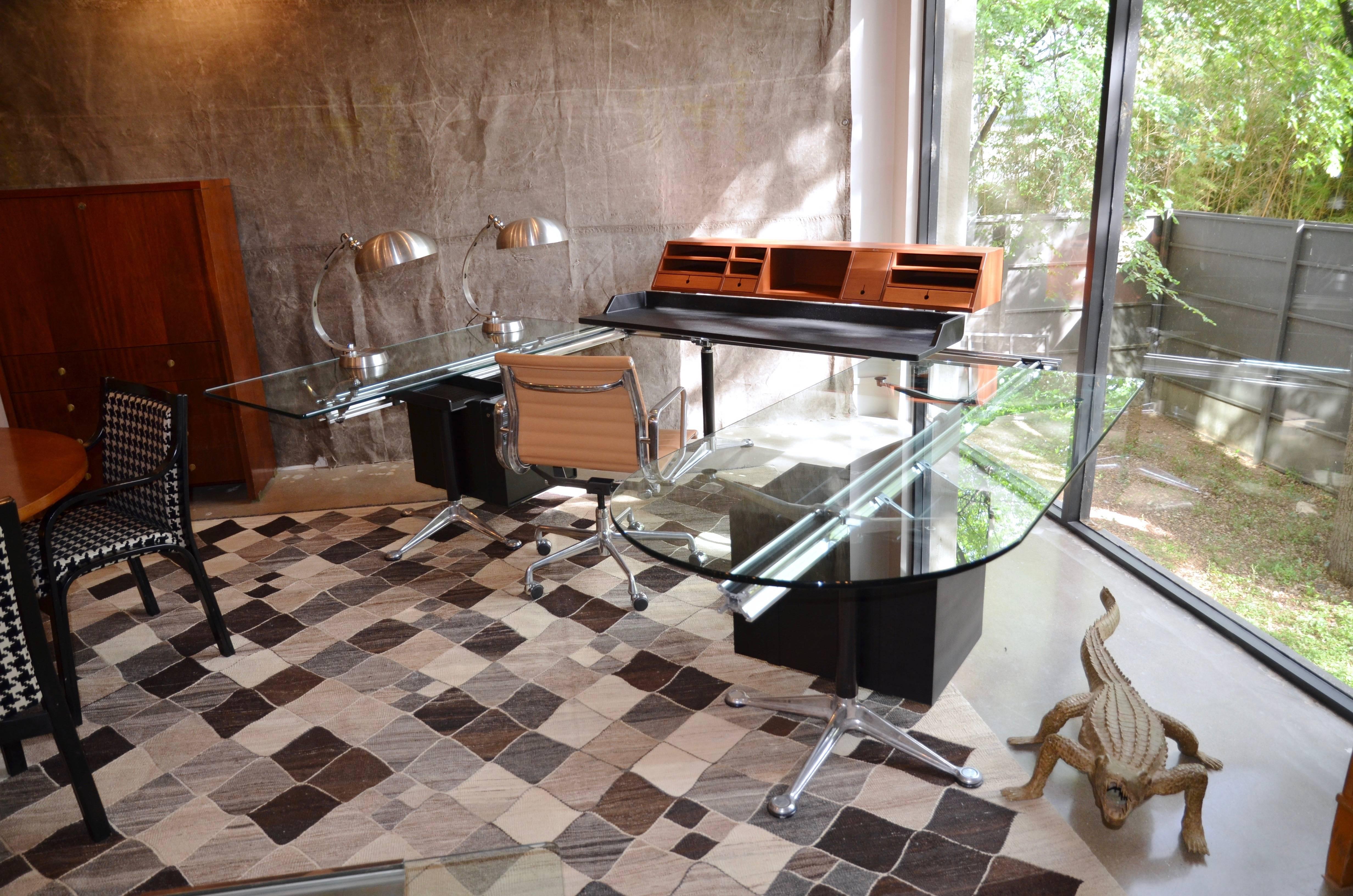 This highly innovative design by Bruce Burdick uses polished aluminum beams supported by legs with splayed cast aluminum feet to suspend glass, wood and heavy plastic composite components. This example has three work surfaces, large wood organizer,