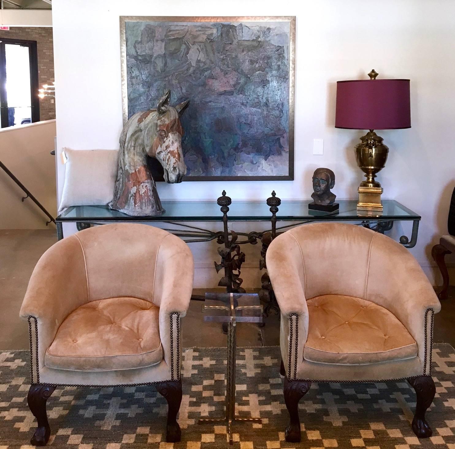 A substantial pair of barrel back armchairs with original suede upholstery, bronze nailheads, down filled seat cushions and carved ball and claw front legs. Very comfortable.