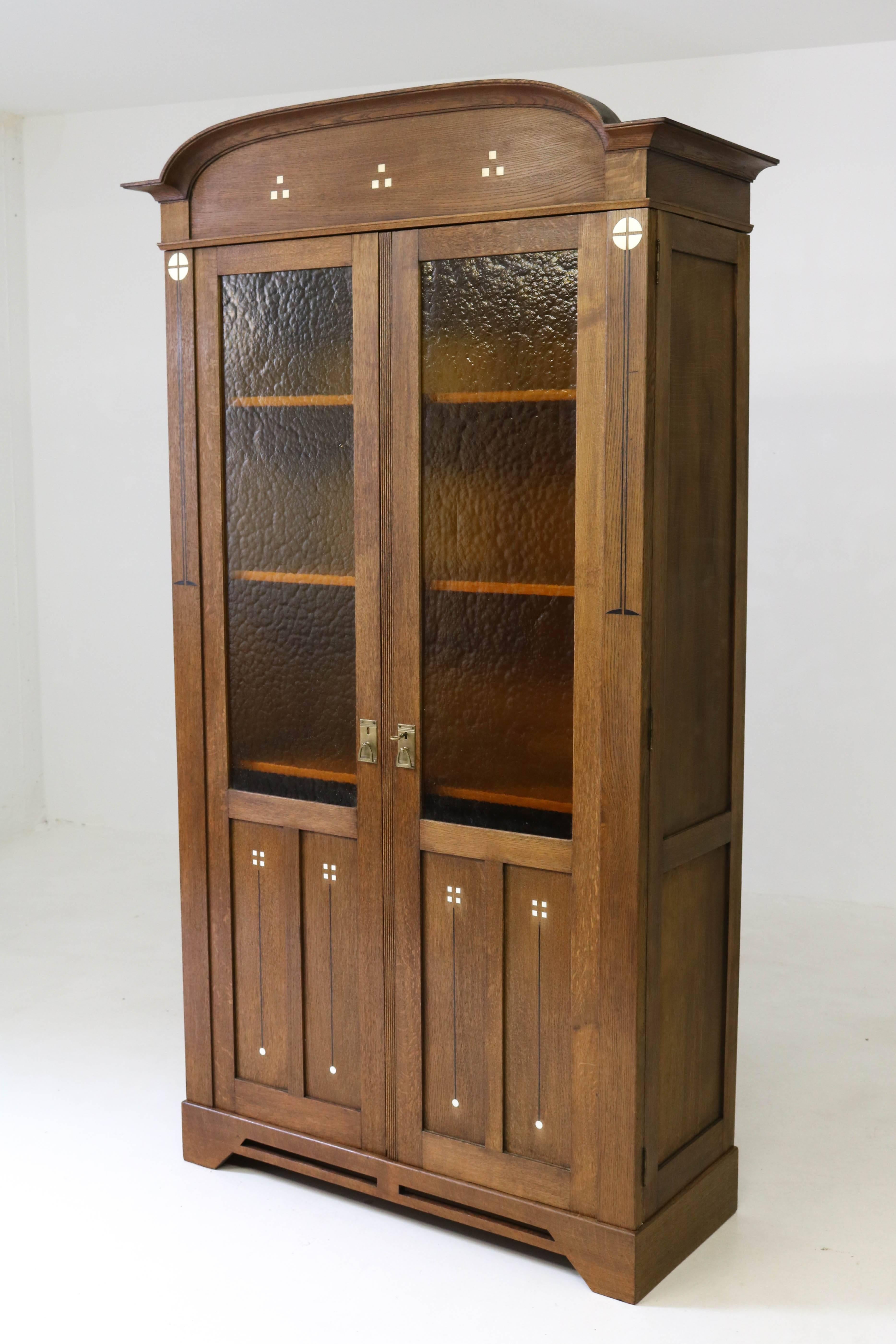 Stunning Dutch Art Nouveau bookcase, 1900s
Solid oak with impressive inlay.
In the style of Chris Wegerif.
The doors have original brown glass.
Four original solid oak adjustable shelves.
Bookcase can be dismantled for transport.
In good