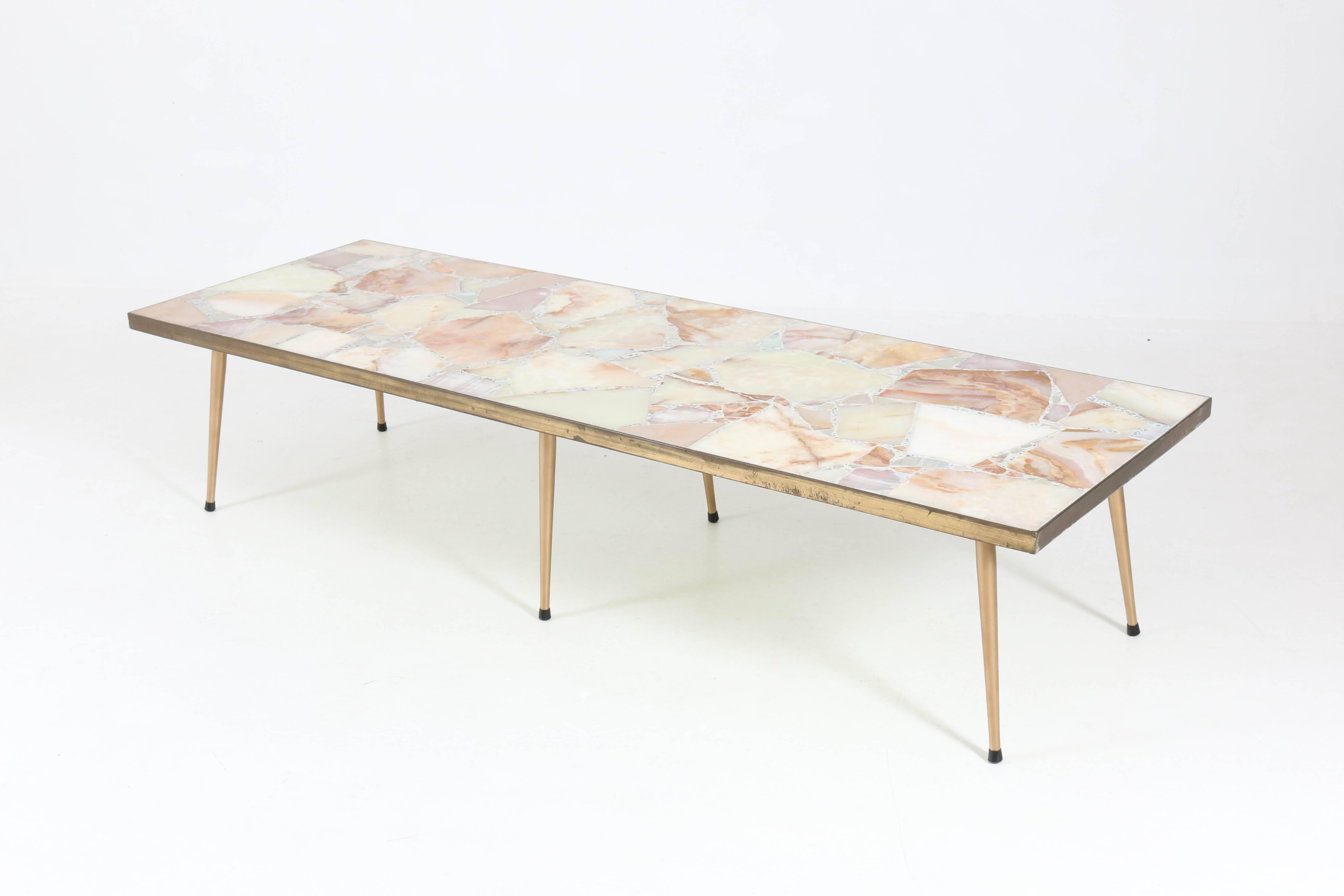 Stunning and rare extra large Mid-Century Modern coffee table.
Elegant Italian design from the 1950s.
Original onyx top in brass and cement.
Six original gilt metal legs.
In good original condition with minor wear consistent with age and