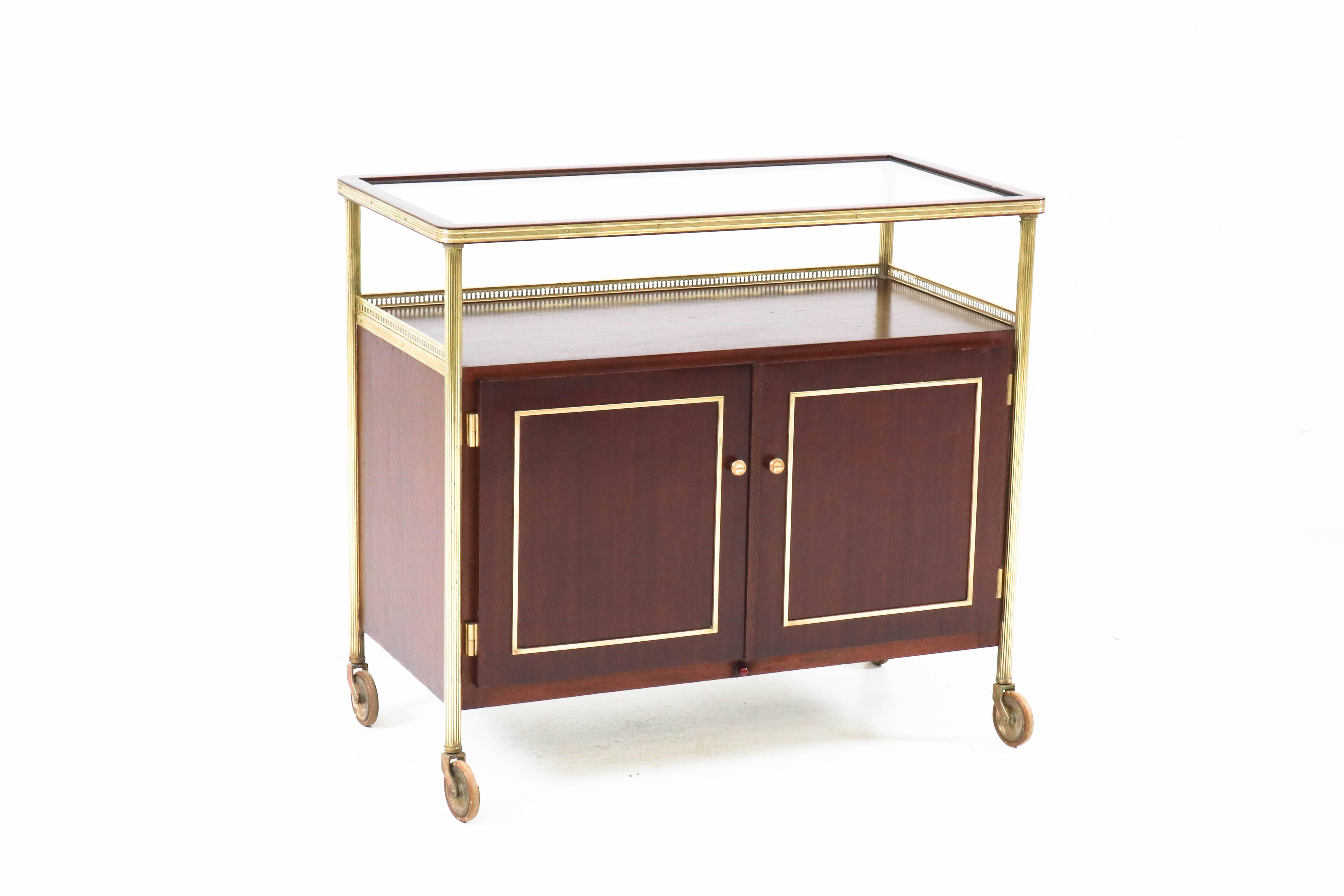 
Offered by Amsterdam Modernism:
Stunning mahogany / brass French Hollywood Regency bar cart, 1950s.
Elegant design.
With integrated cooling.
In good condition with minor wear consistent with age and use,
preserving a beautiful patina.