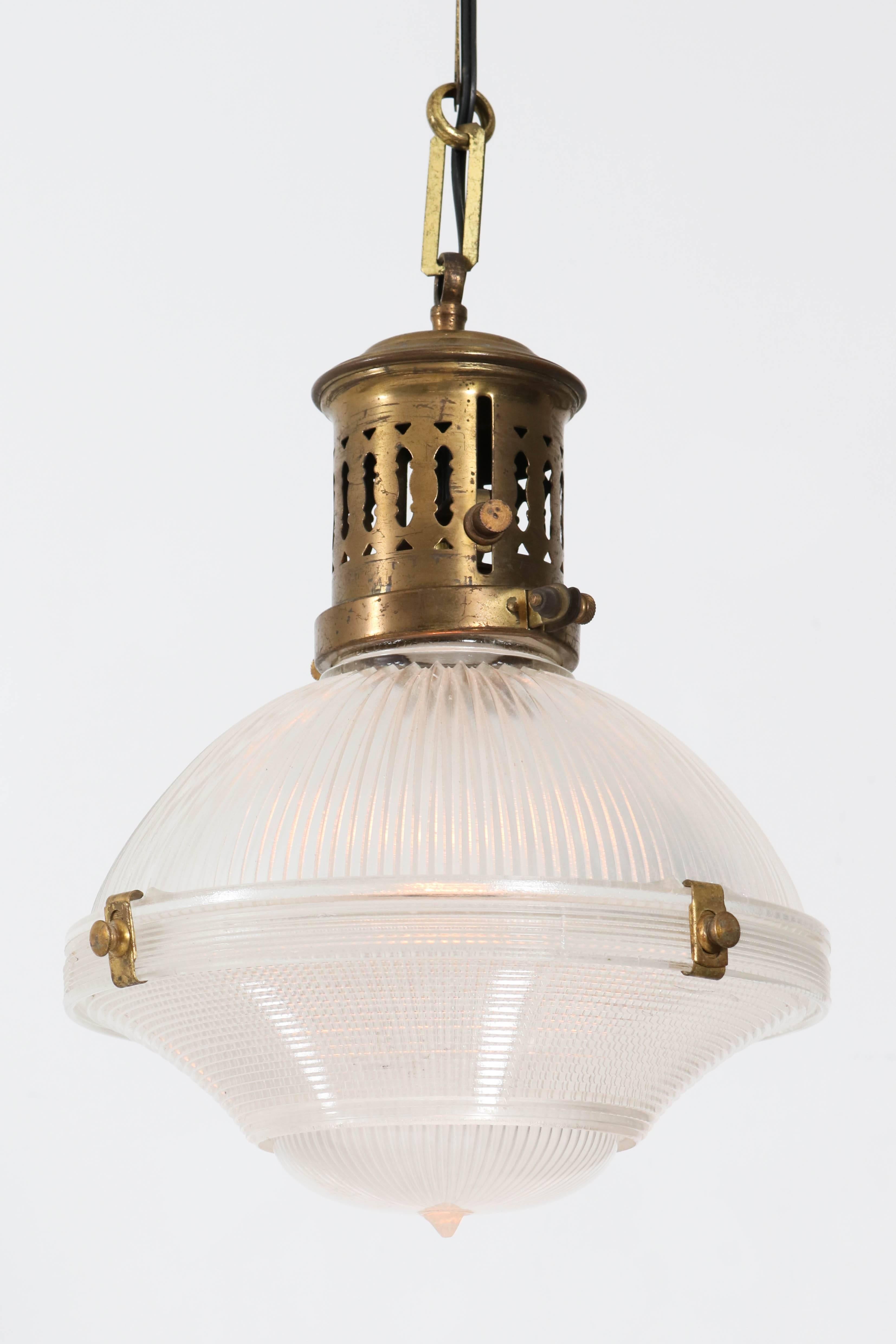Rare three-piece Holophane pendant light, 1915.
Early design with brass and prismatic glass shades.
This shade has three pieces, the two larger parts are held together
with four snap on clips.
The third part is the small bottom dome insert, the