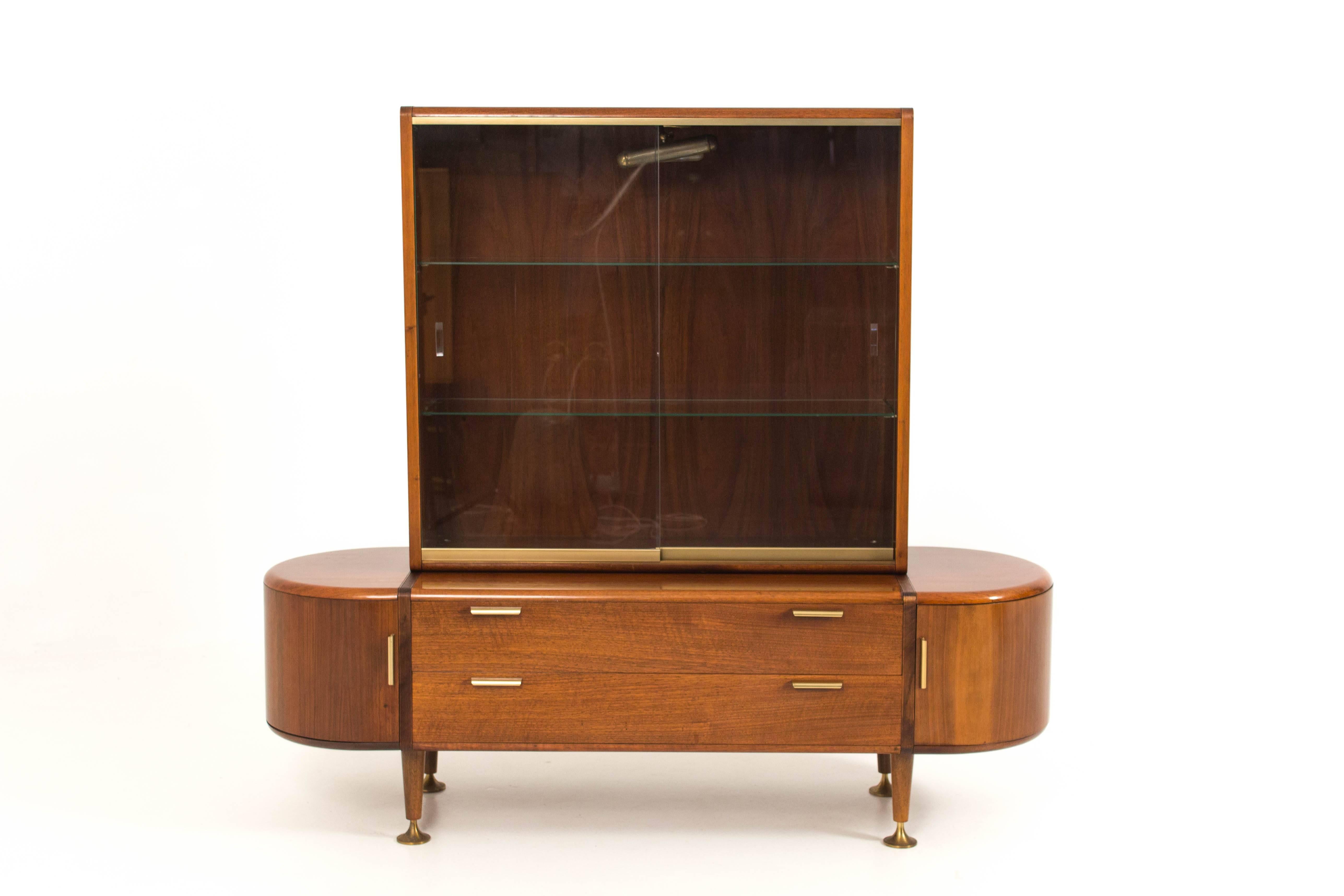 Stunning walnut Mid-Century Modern vitrine by A. A. Patijn for Poly-Z.
Original glass sliding doors.
Round bended doors and brass handles and feet.
In good original condition with minor wear consistent with age and use.
Preserving a beautiful