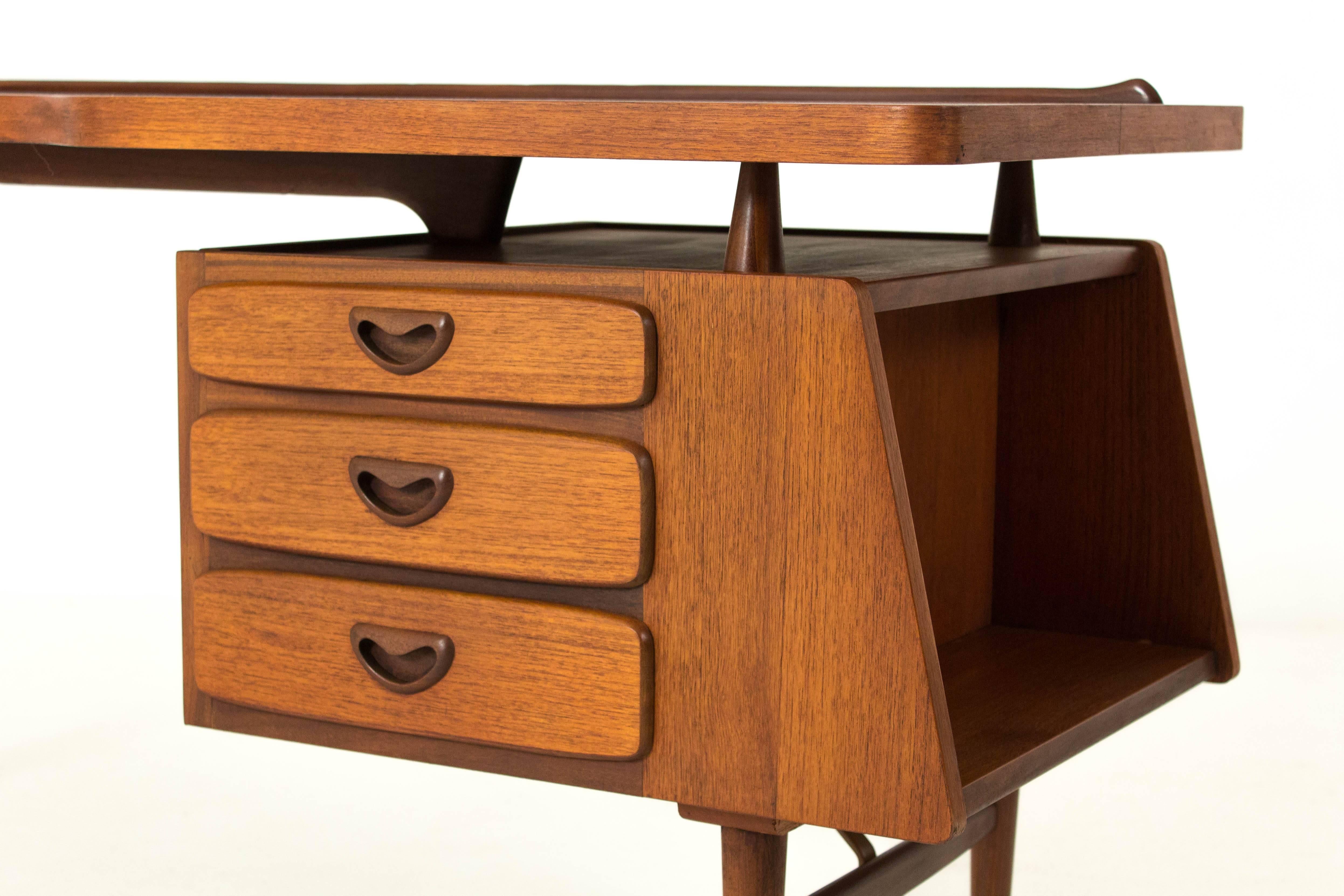 Iconic Mid-Century Modern desk by Louis van Teeffelen for Webe 1959.
Striking design with floating top.
Teak with brass supports.
Please note that our desk is 100% original with the correct support between
the curved and tapered legs on the left