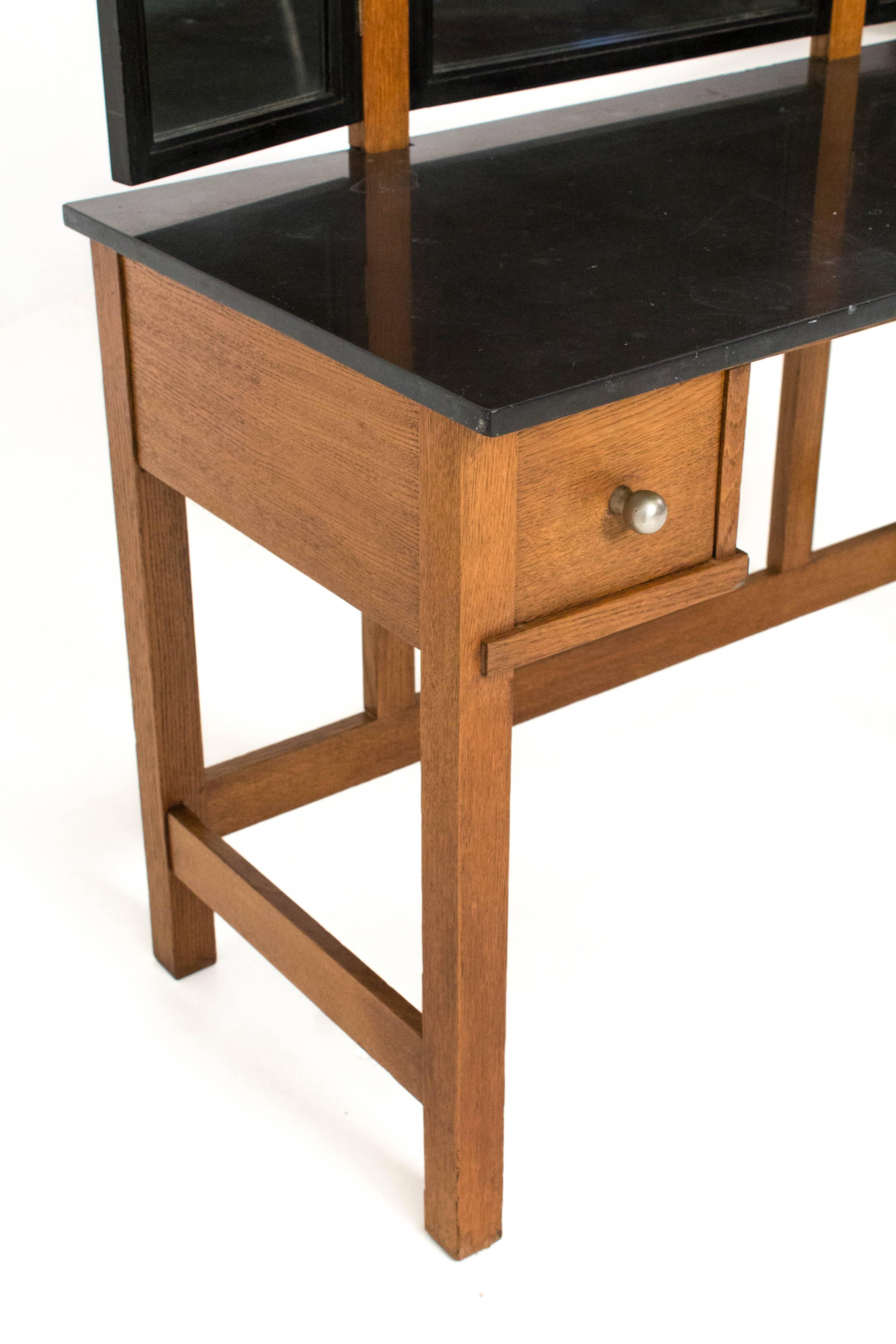 Rare Art Deco Haagse School dressing table or vanity by Henk Wouda for Pander.
Solid oak with ebonized details and original black granite top.
The two drawers have original nickel knobs.
Marked with metal tag Pander on the back of the mirror and