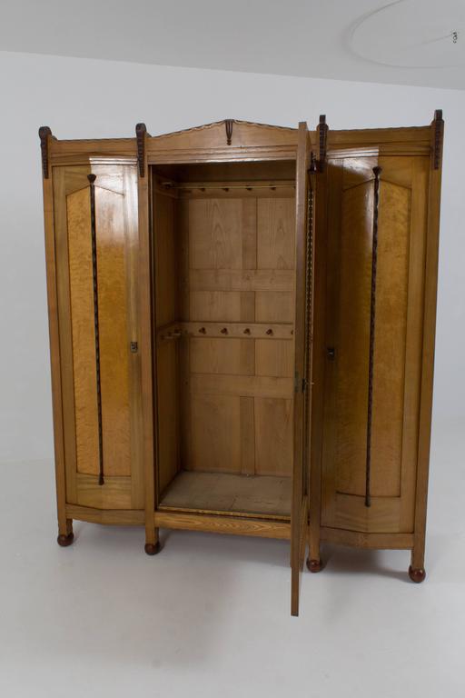Impressive and rare Art Deco Amsterdam School wardrobe by F.A.Warners for H.F.Jansen & Zonen Amsterdam.
Ashwood, burl wood and wenge.
Ten original shelves and four drawers.
Marked on the original keys.
The mid-section with the mirror can be