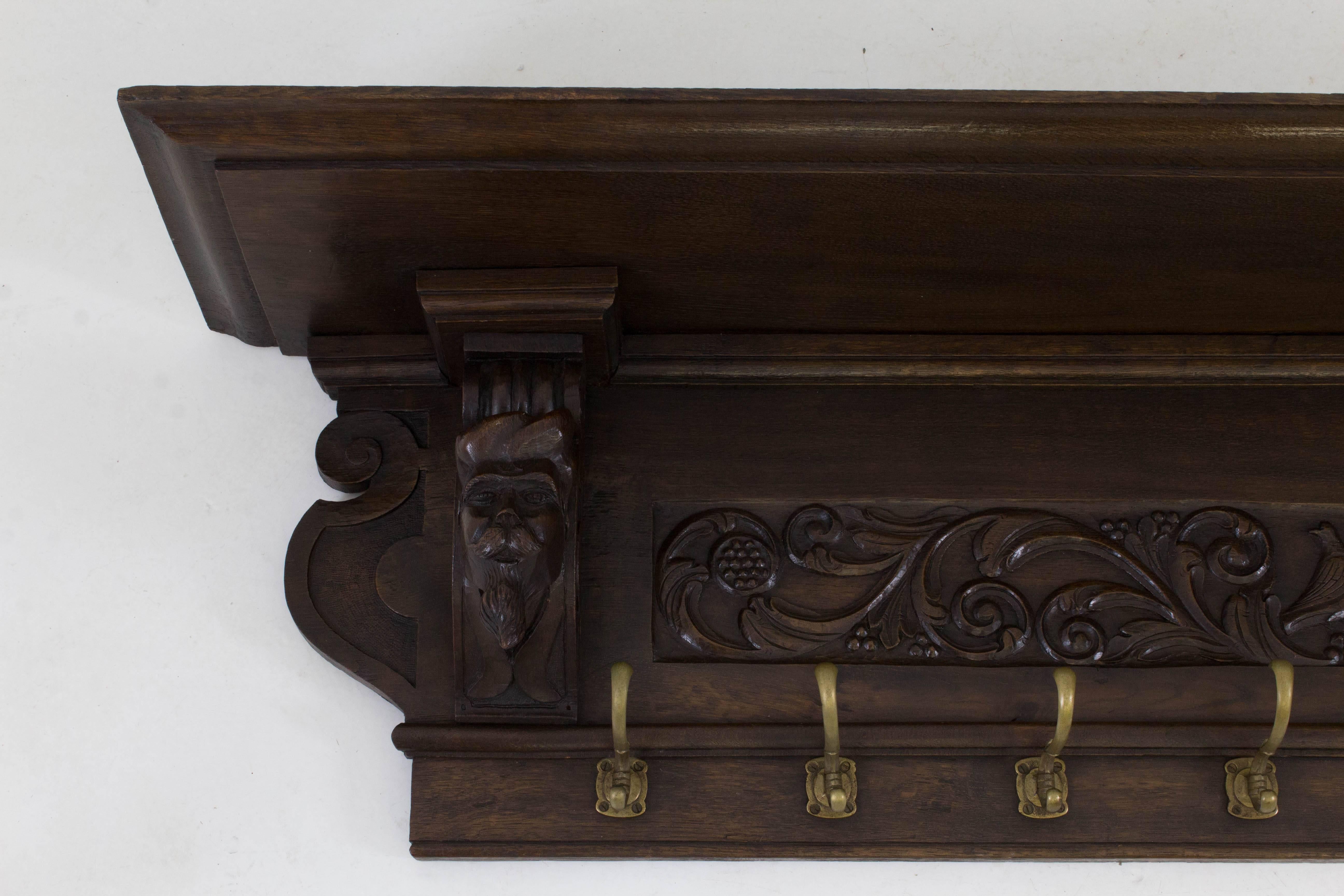 Large and rare Renaissance Revival carved coat rack, 1890s.
Solid oak with nicely carved male heads.
Eight original brass hooks.
In good original condition with minor wear consistent with age and use,
preserving a beautiful patina.