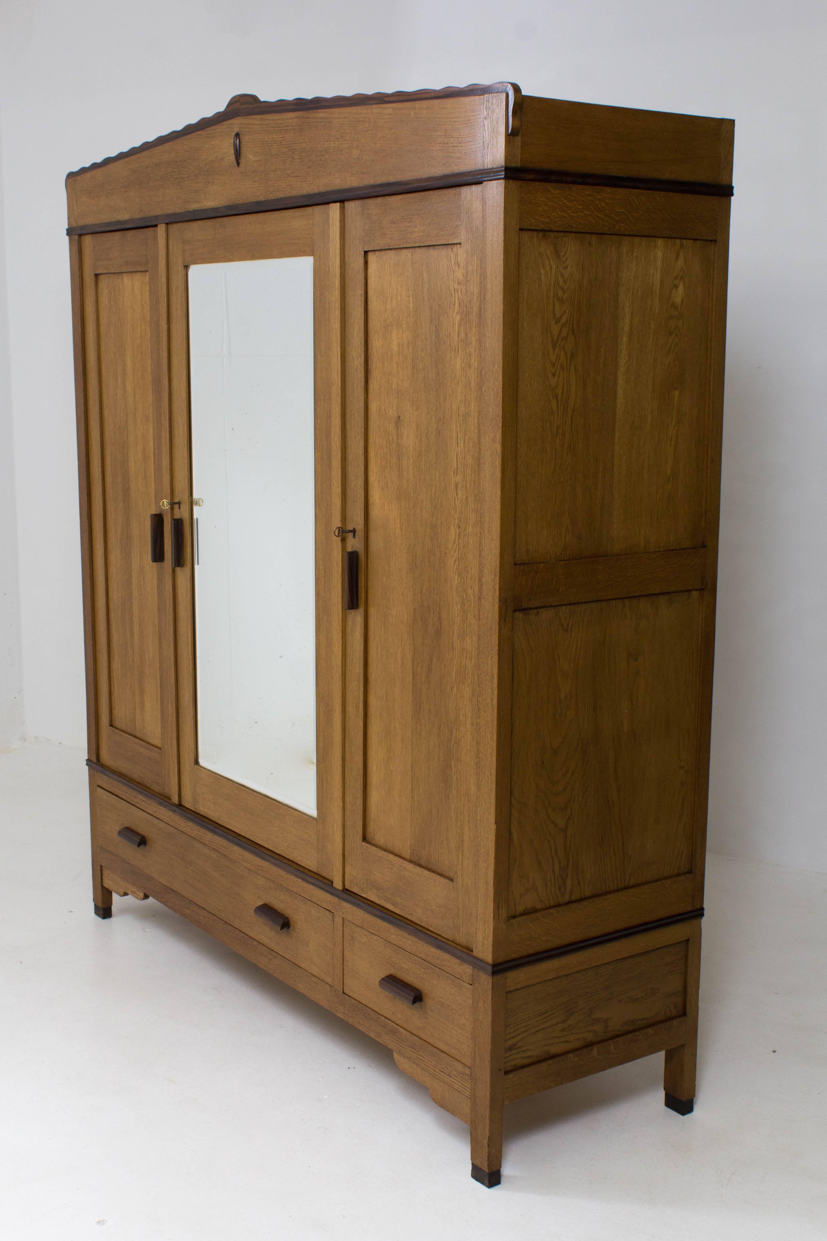 Stunning oak and ebony Macassar Art Deco Amsterdam School wardrobe by Fa.Drilling, Amsterdam, 1920s.
Marked on the two original keys.
The door in the middle has the original bevelled mirror.
This wardrobe can be dismantled for transport.
Four