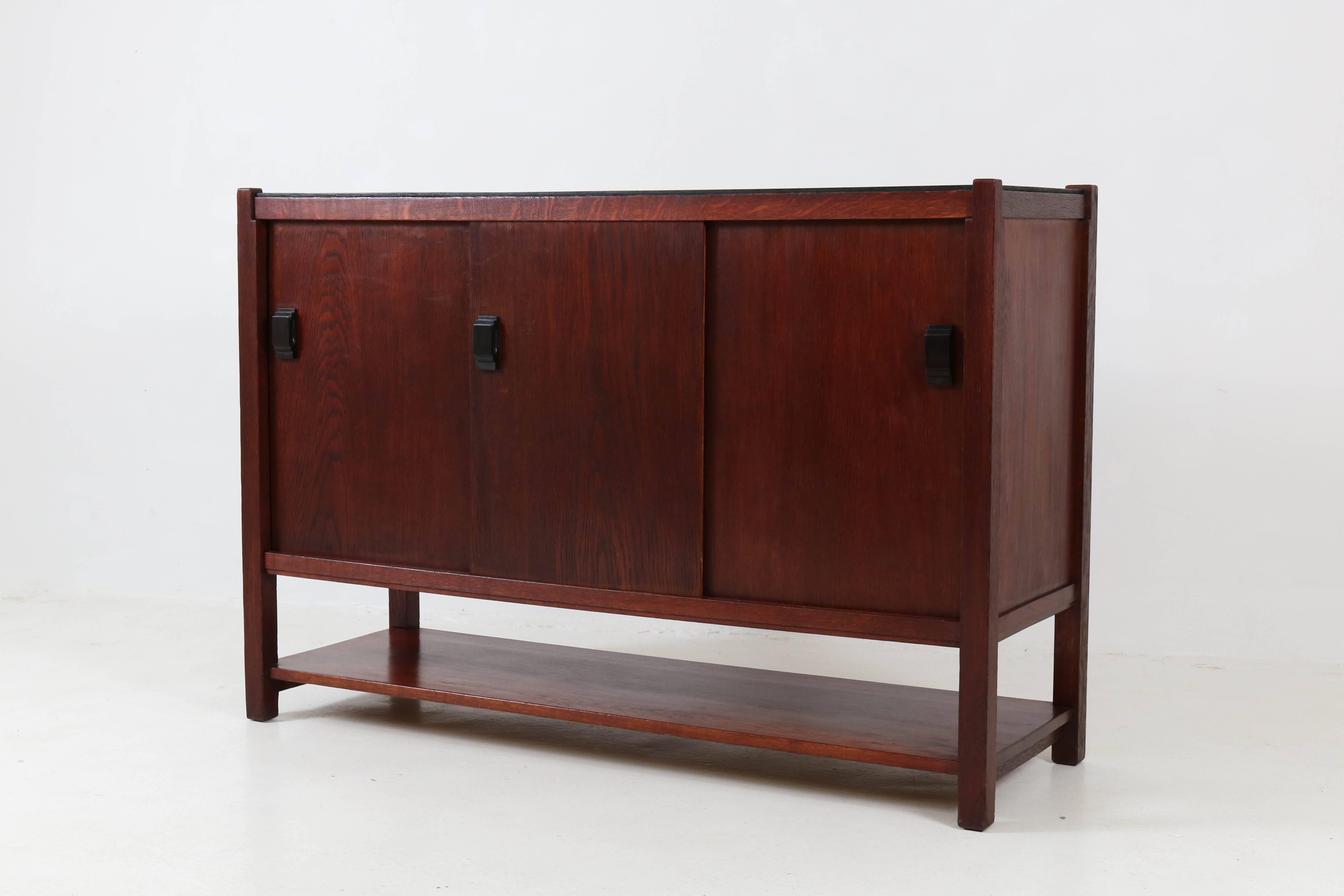 Rare Art Deco Haagse school sideboard or credenza by Frits Spanjaard for L.O.V. Oosterbeek, 1920s.
Mahogany stained solid oak with original ebonized top.
Three original Macassar ebony handles on the sliding doors.
Marked with L.O.V. tag.
In good