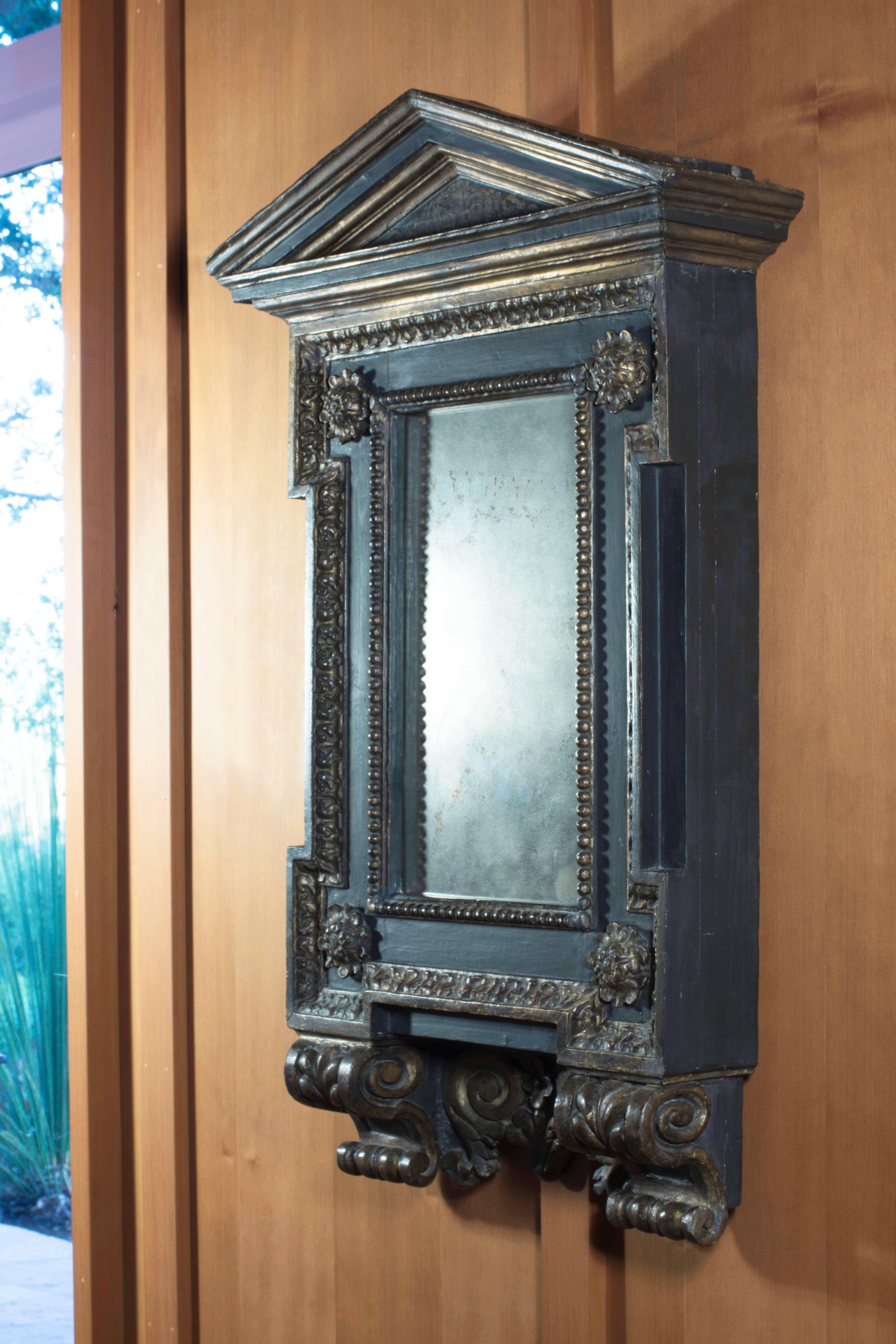 We were drawn to this handsome carved, painted and gilded mirror from the collection of David Abbato especially for its affinities to door and window surrounds designed by our favorite Renaissance architects. Attached, for example, is an image of