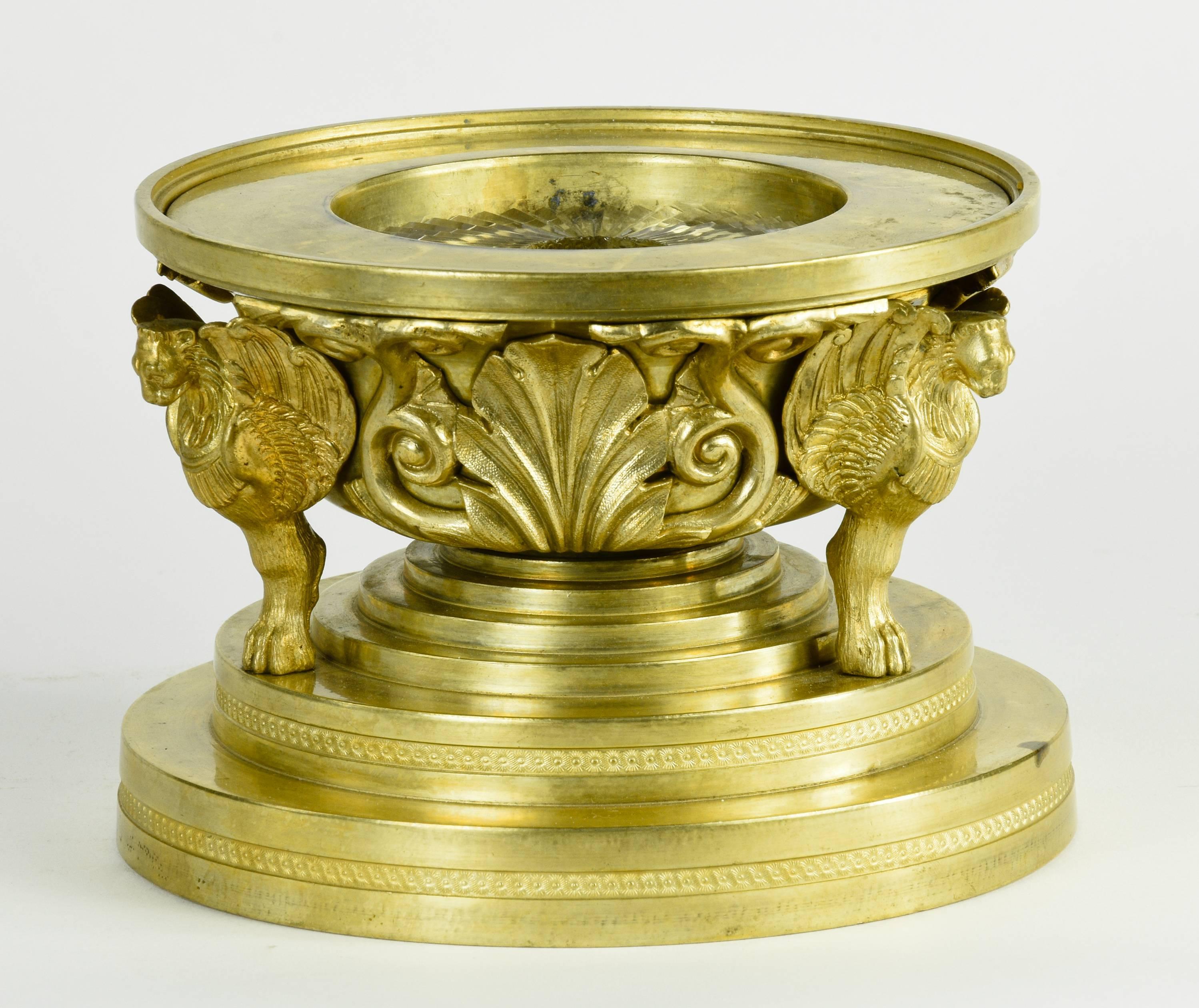 Cast brass lamp with highly detailed lionfoot base on a tied plinth, with glass insert. 
Probably English, circa 1900. 

The elegant and highly detailed neoclassical brass lamp is designed in the form of a Roman tazza supported by three