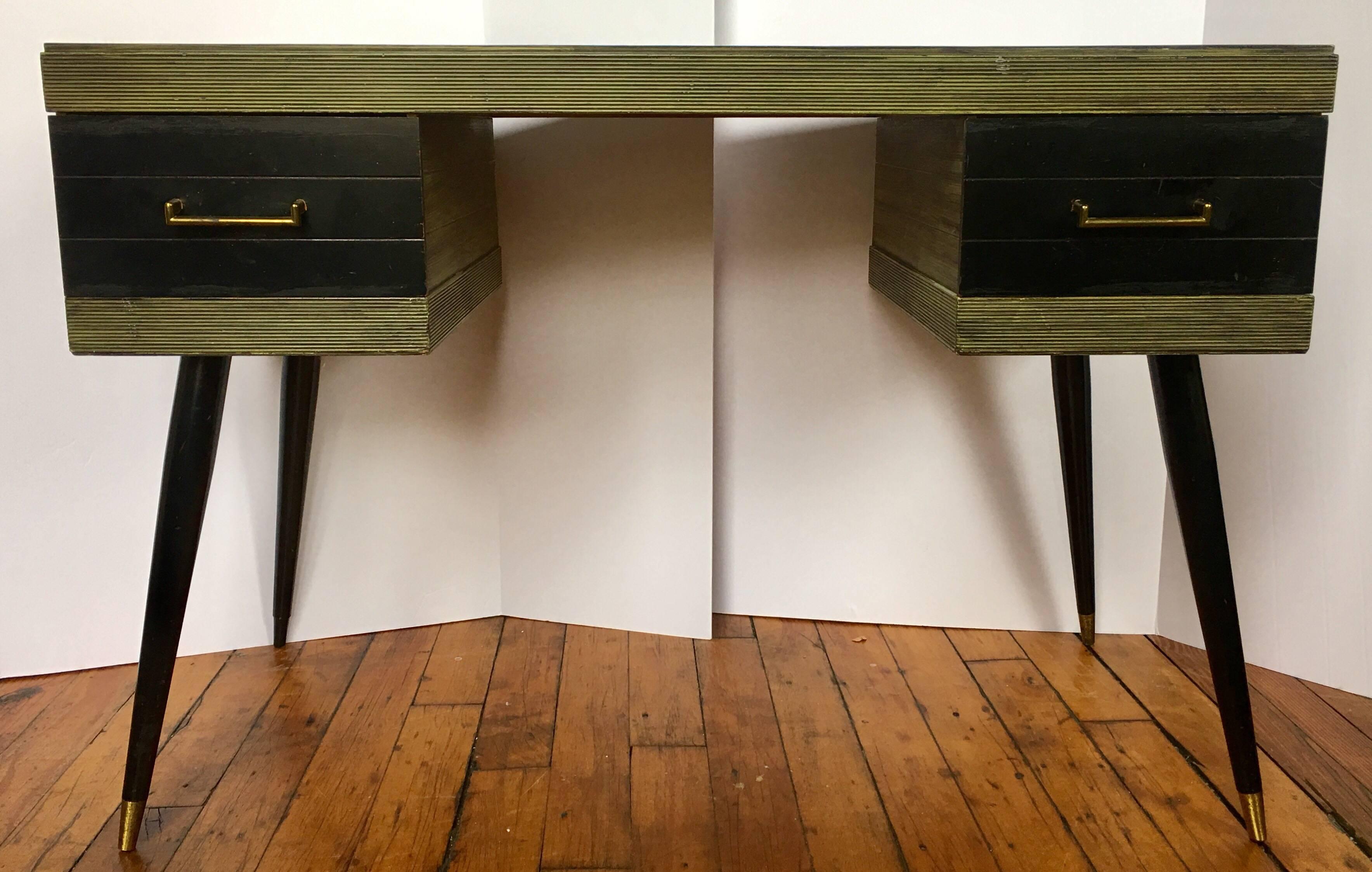 Mid-Century Modern desk and bookcase shelving unit in the style of Ico Parisi. This two-drawer writing desk features original green and black painted/glazed finish with ribbed edge detailing and Classic brass capped tapered legs. Matching bookcase