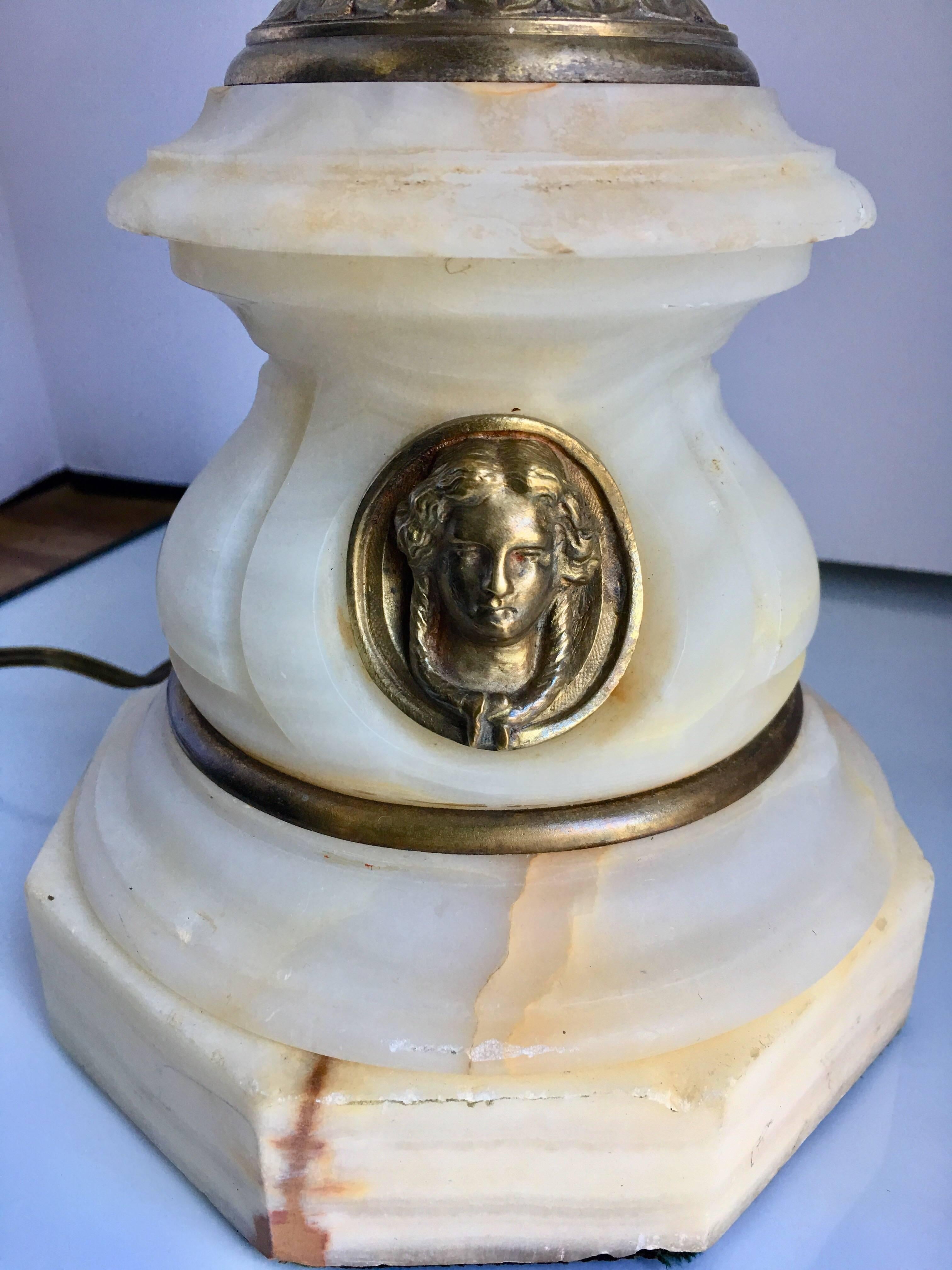 1920s neoclassical style French table lamp featuring a silver plated and brass handled urn mounted on an octagonal marble base with decorative figural bust, France, 1920s.
Lamp shade not included.