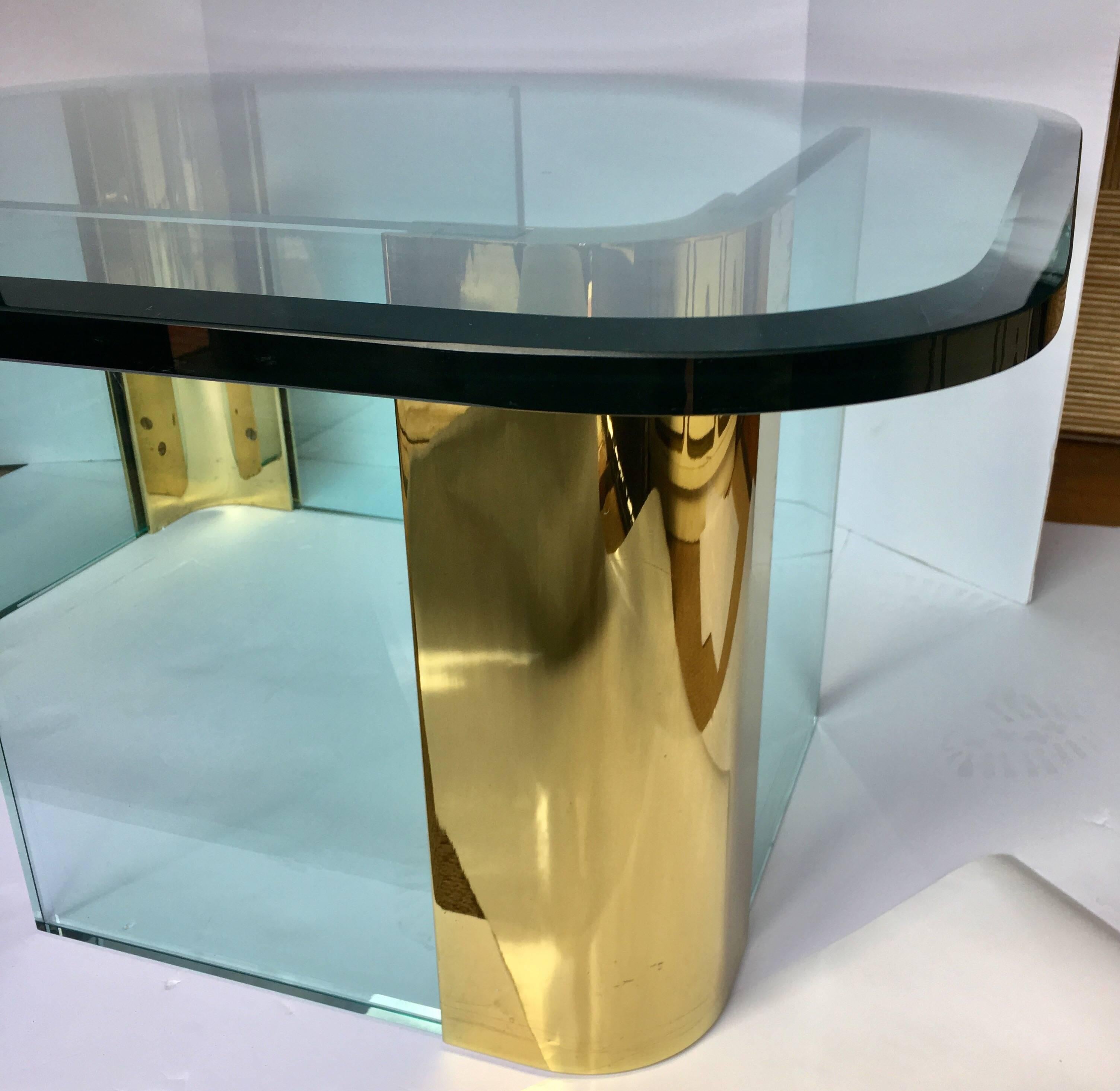 Modern asymmetrical glass and brass cocktail table in the style of Leon Rosen for Pace. Thick removable clear glass top features a rounded curved design with a beveled edge. Two free-standing base units are comprised of two vertical 3/4