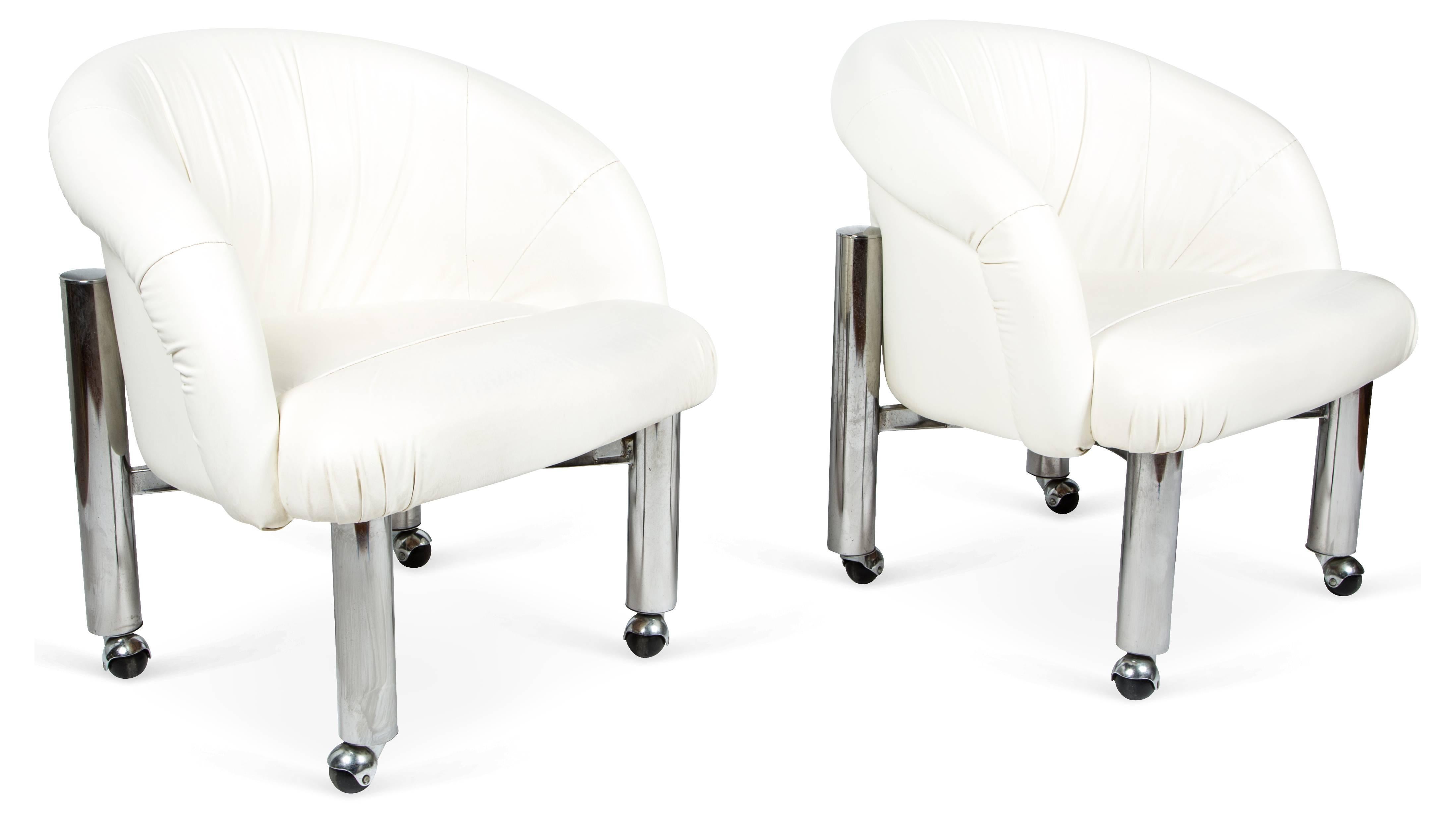 Set of four Midcentury lounge, dining, or game table chairs featuring tubular chrome frames and rolling casters. Original white faux leather white upholstery. These ultra glamorous armchairs are in the style of Milo Baughman for Design Institute