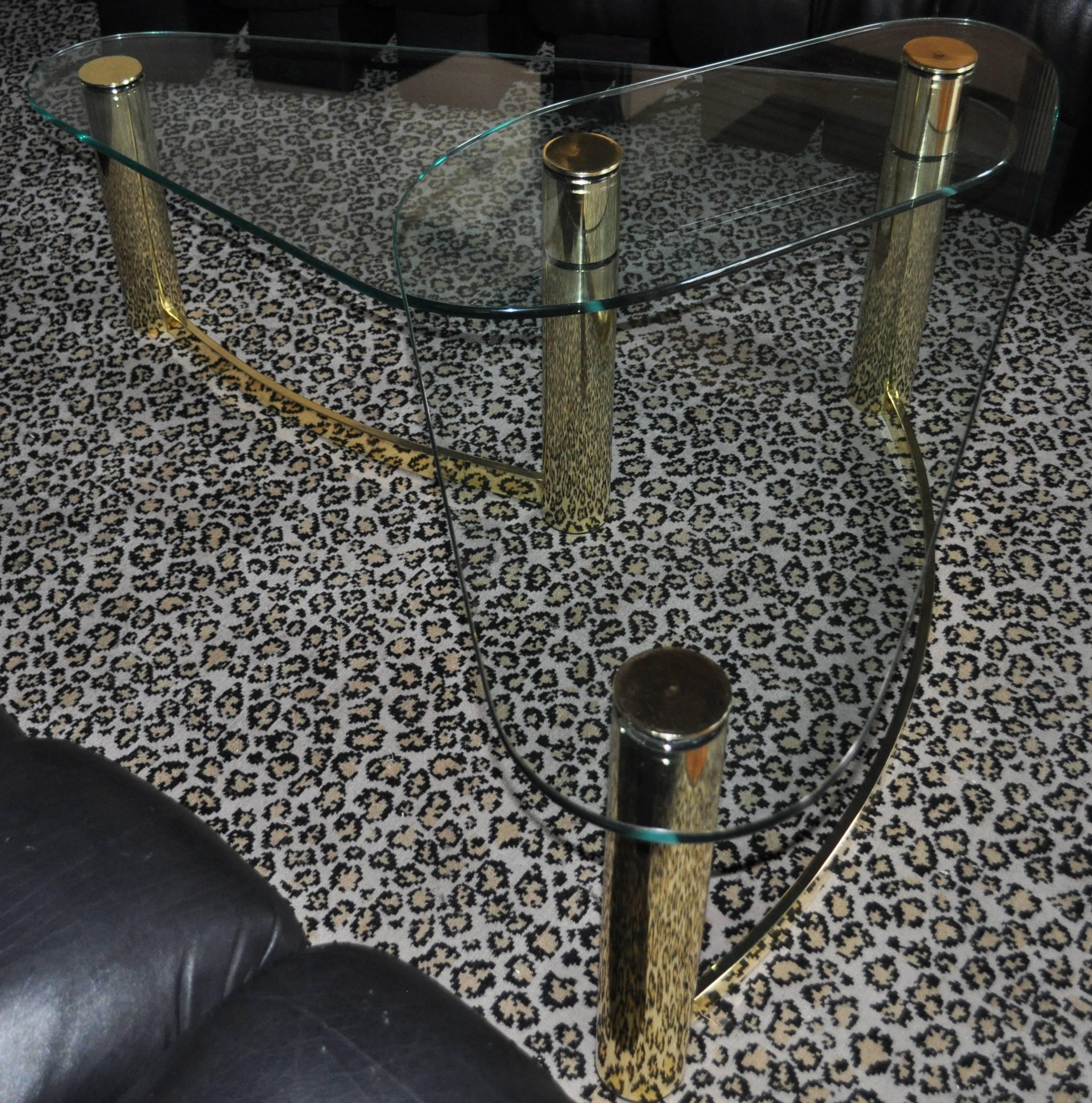 Table basse sculpturale à deux niveaux, en tube de laiton et verre, de style Mid-Century Modern. Cette table de cocktail en forme de boomerang est le style de la collection Pace.

Les deux plateaux en verre fixes sont de la même taille.  Chaque