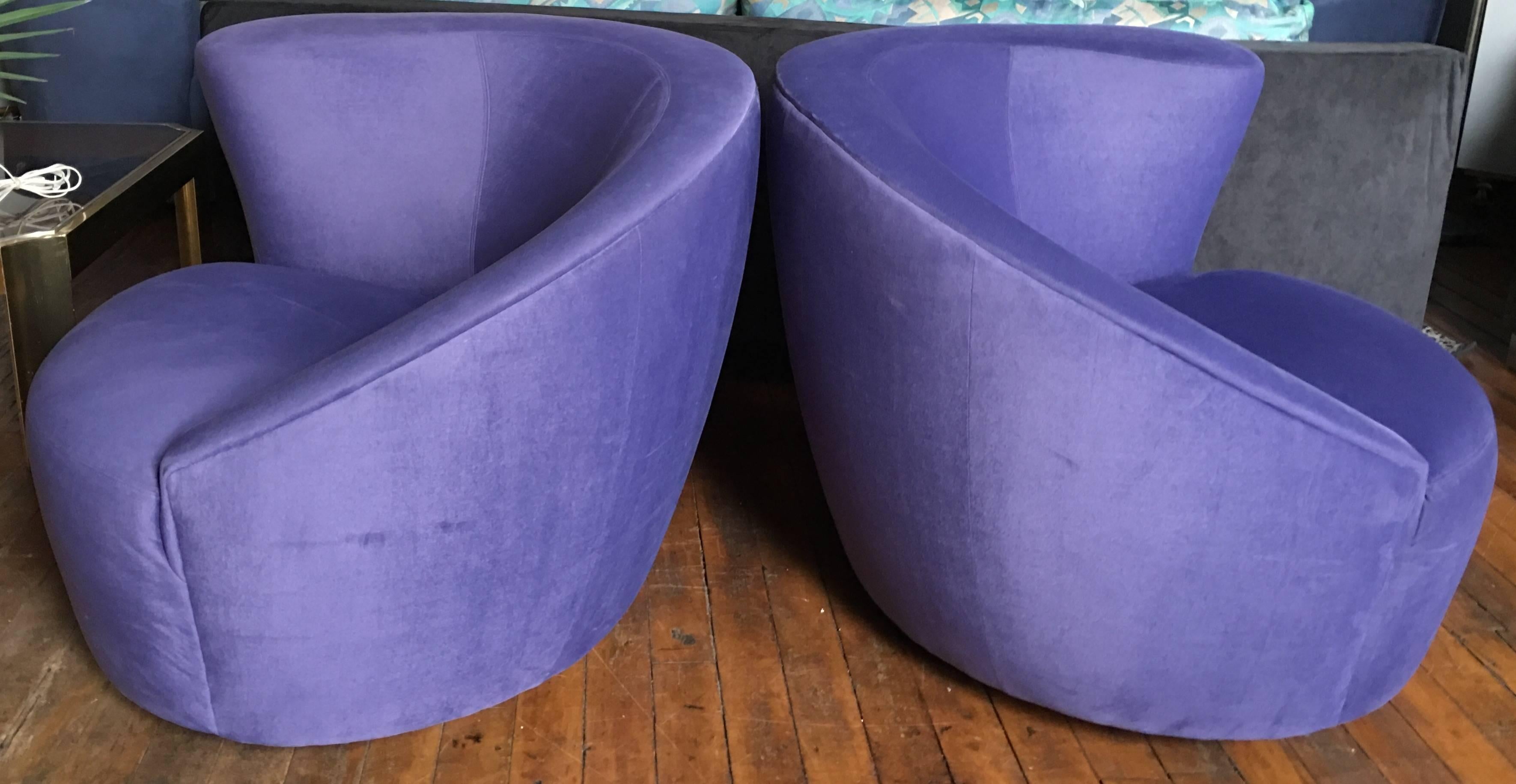 Pair of Nautilus swivel lounge chairs designed by Vladimir Kagan for Weiman Preview. Chairs feature original lavender/purple tone ultra suede upholstery. Swivel bases rotate 180 degrees and return to original position when released. Original Weiman