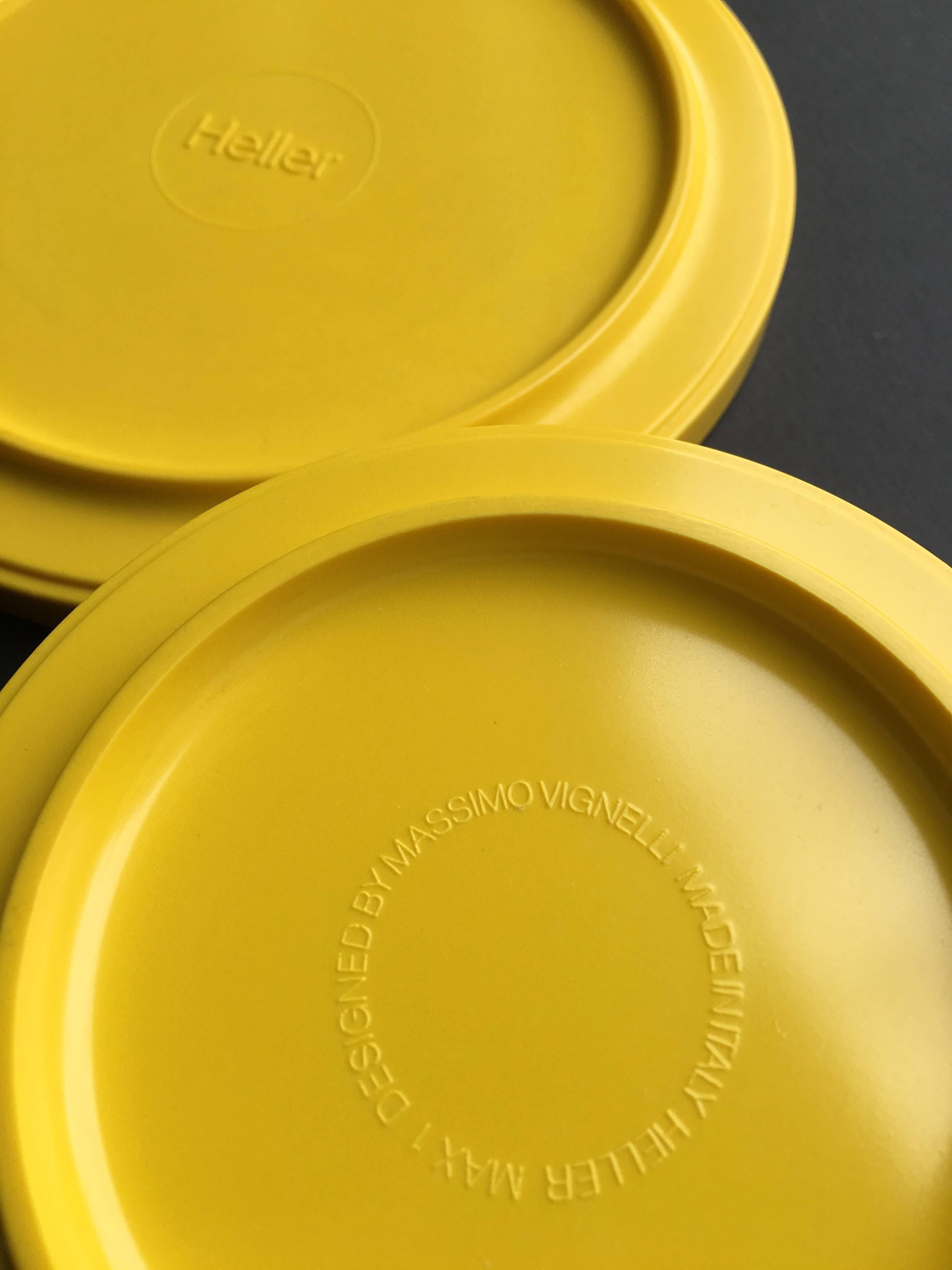 Iconic 46 piece collection of vibrant yellow melamine dinnerware designed by Massimo Vignelli for Heller. This compact, stackable design is in the permanent collection at the Museum of Modern Art and the Metropolitan Museum. Two plates by Dansk also