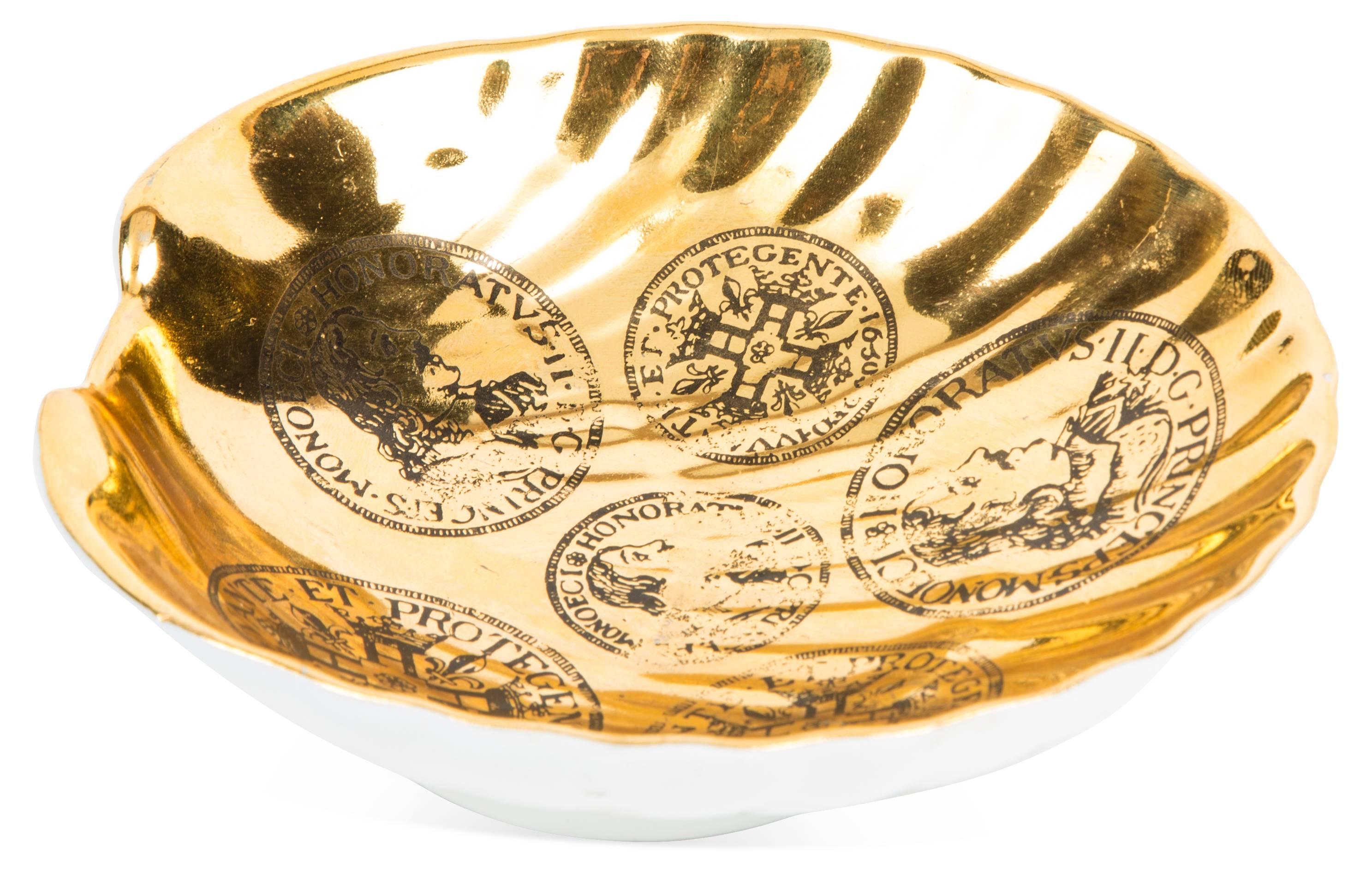 Fornasetti style white and gold porcelain shell form dish with trompe-l'œil coin/bust decoration.
 