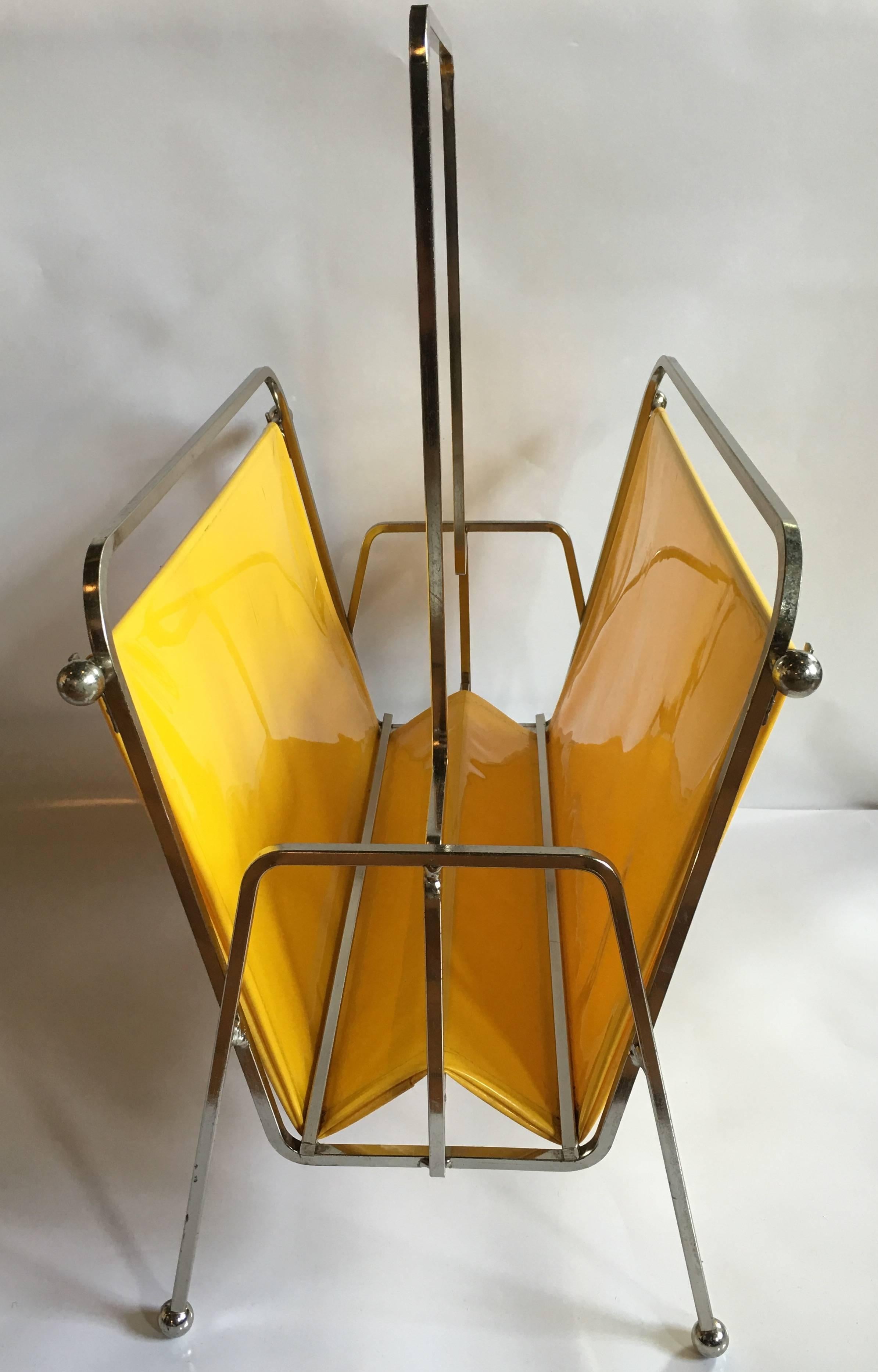 Mid-Century Modern magazine rack holder in the style of Jacques Adnet.
Chrome frame with original vibrant yellow vinyl liner.