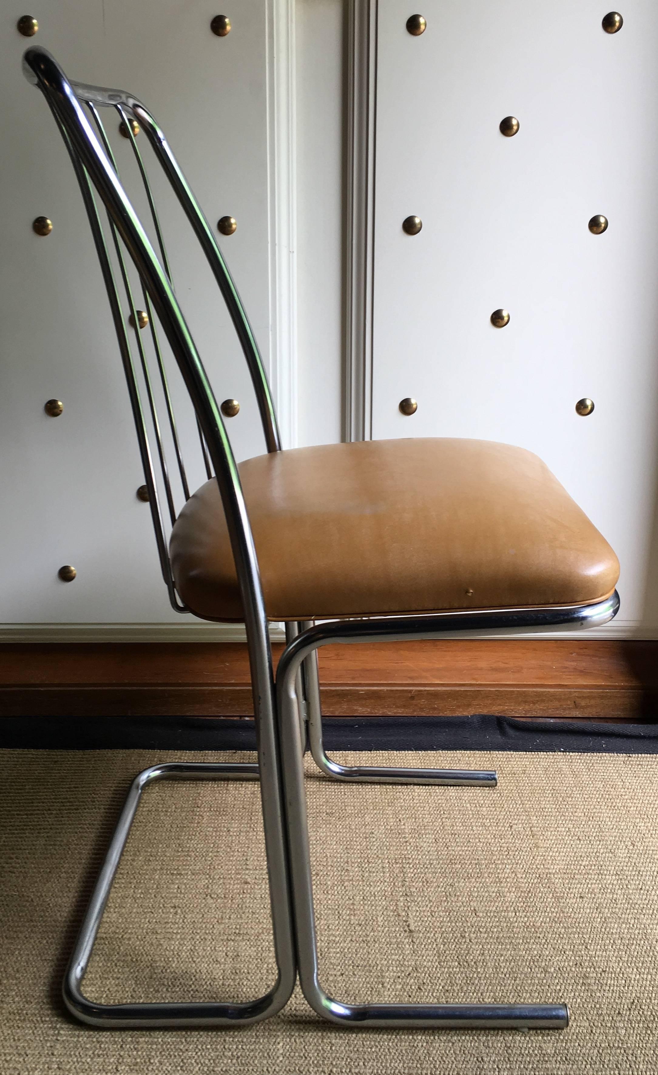 Set of four Mid-Century Modern chrome dining chairs featuring a cantilevered tubular metal frame and a wire back design. Original vinyl upholstery.