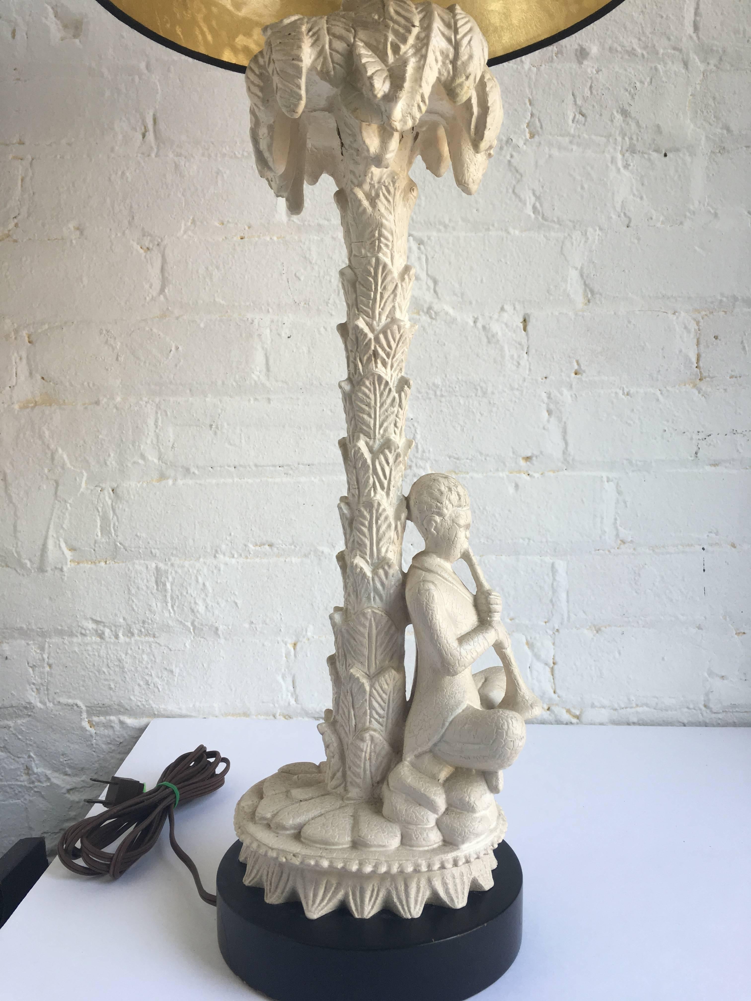 Mid-Century chinoiserie style plaster and wood palm tree lamp by Chapman. Base features detailed palm tree and musical figure in original cream painted finish. Mounted on black wood base. Original wiring in working condition. Lamp shade not