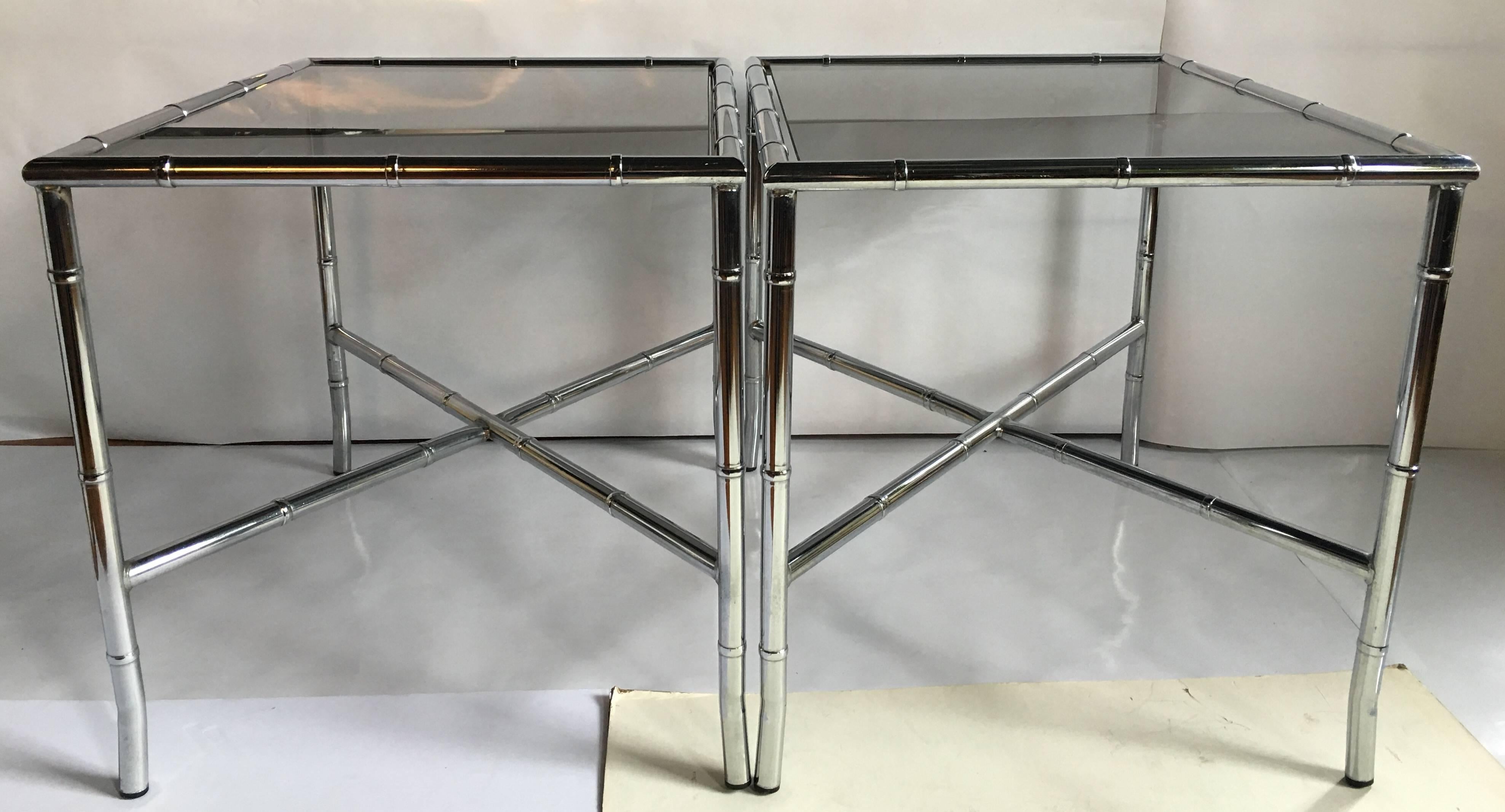 Pair of Hollywood Regency or palm regency faux bamboo chrome end tables with smoked glass tops. Base features X-stretcher design. Tables can be used as side tables or be paired together as a cocktail table.
Original labels, made in Canada.