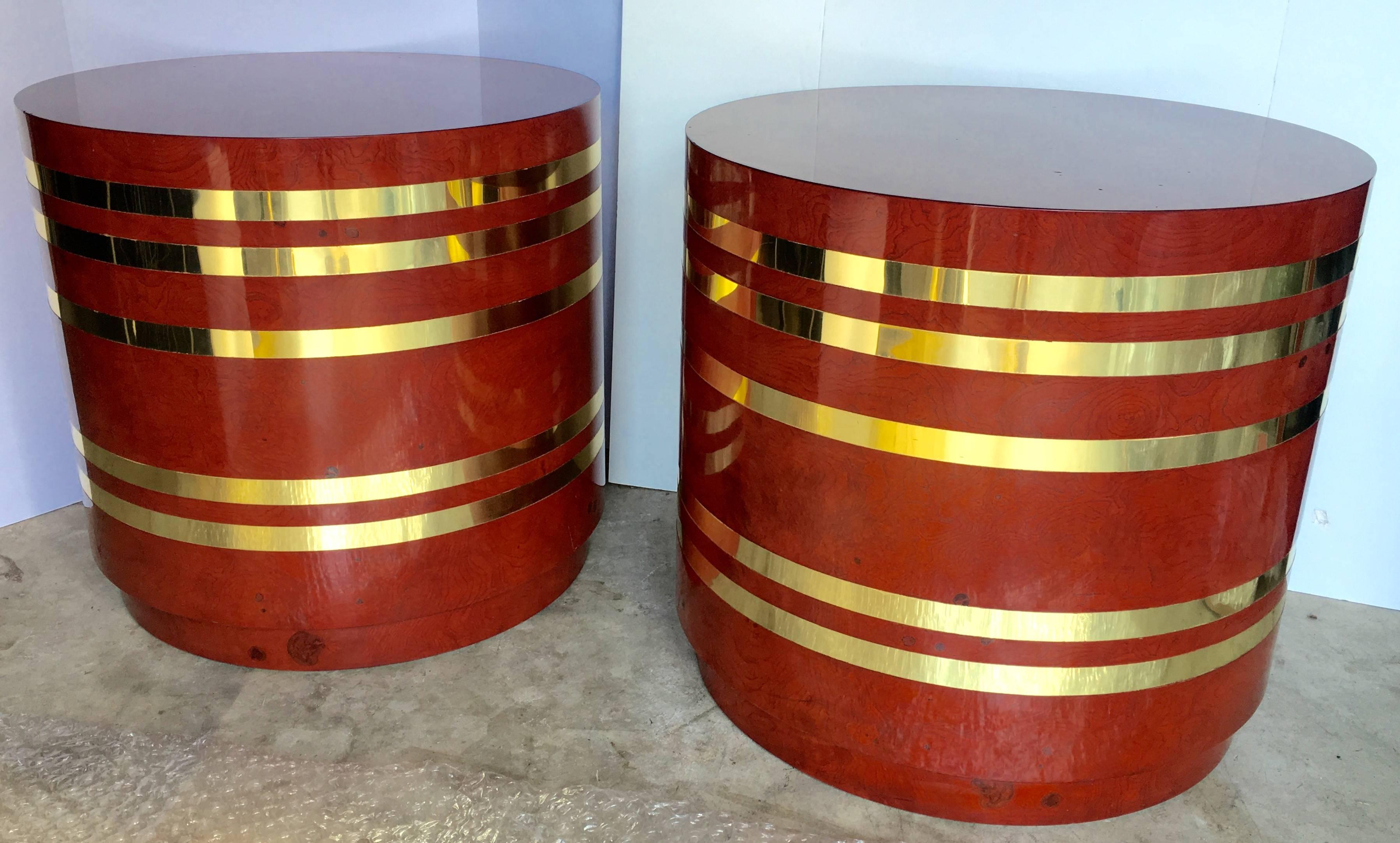 Stunning pair of large Mid-Century Modern round end side drum tables. These column pedestals feature red/burgundy burl wood veneer with striped brass bands. Beautiful glossy lacquer-like finish to burl wood. Can also be used as a unique set of