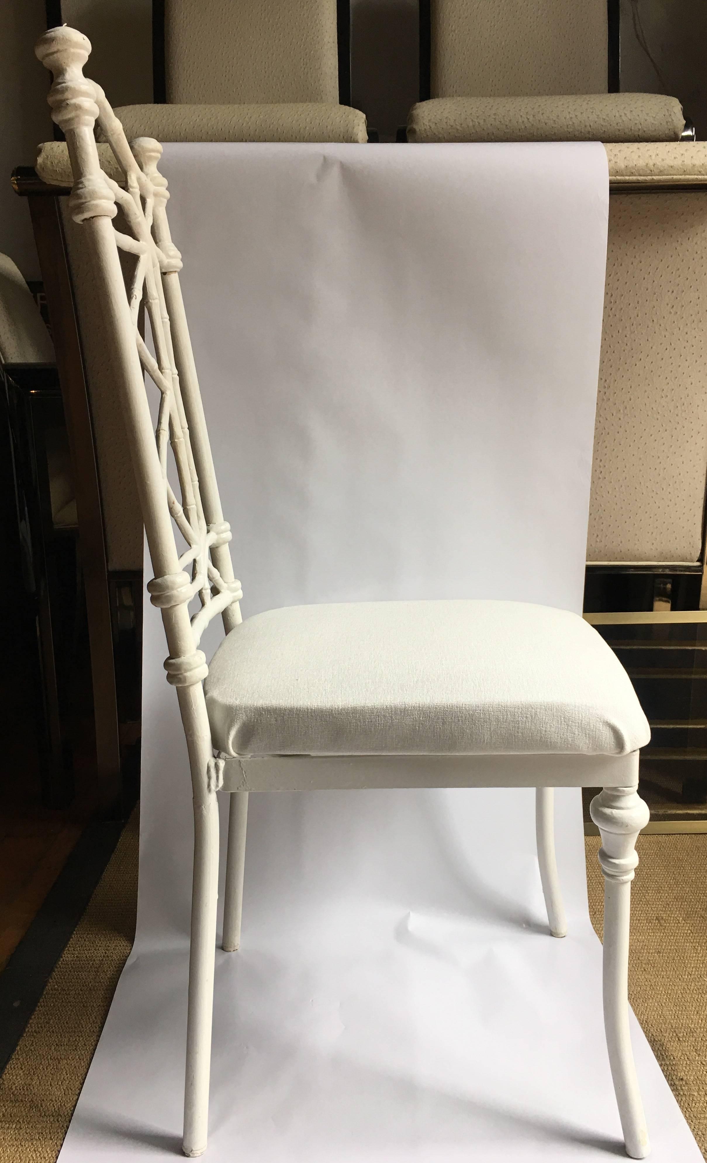 Set of six Hollywood Regency or chinoiserie style faux bamboo dining chairs with cream painted metal frames.