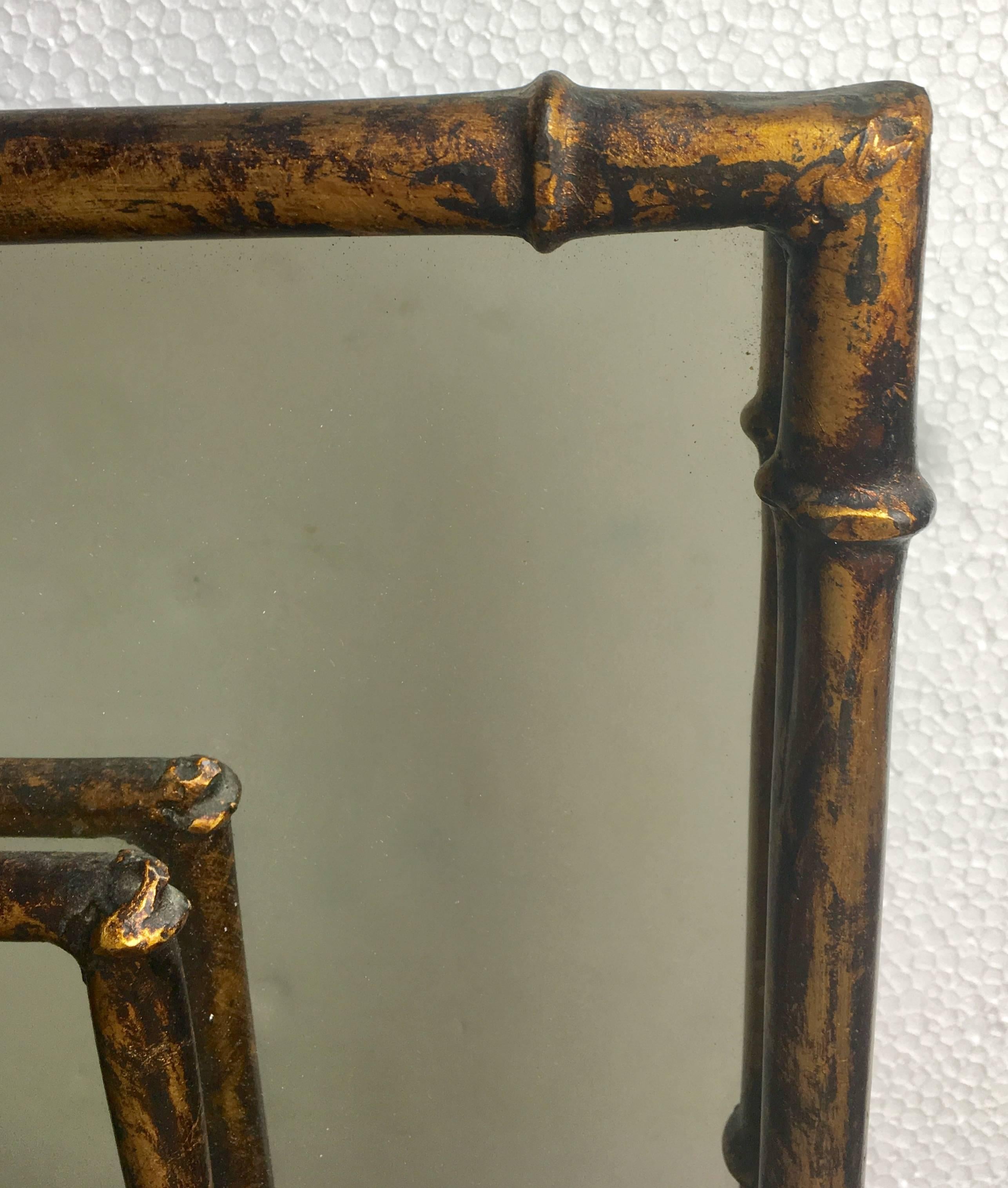 Mid-Century sculptural gilt metal faux bamboo mirror in the manner of Maison Bagues. Palm Regency style rectangular metal frame features a detailed bamboo motif with original gilt finish. Labeled, made in Spain.
  