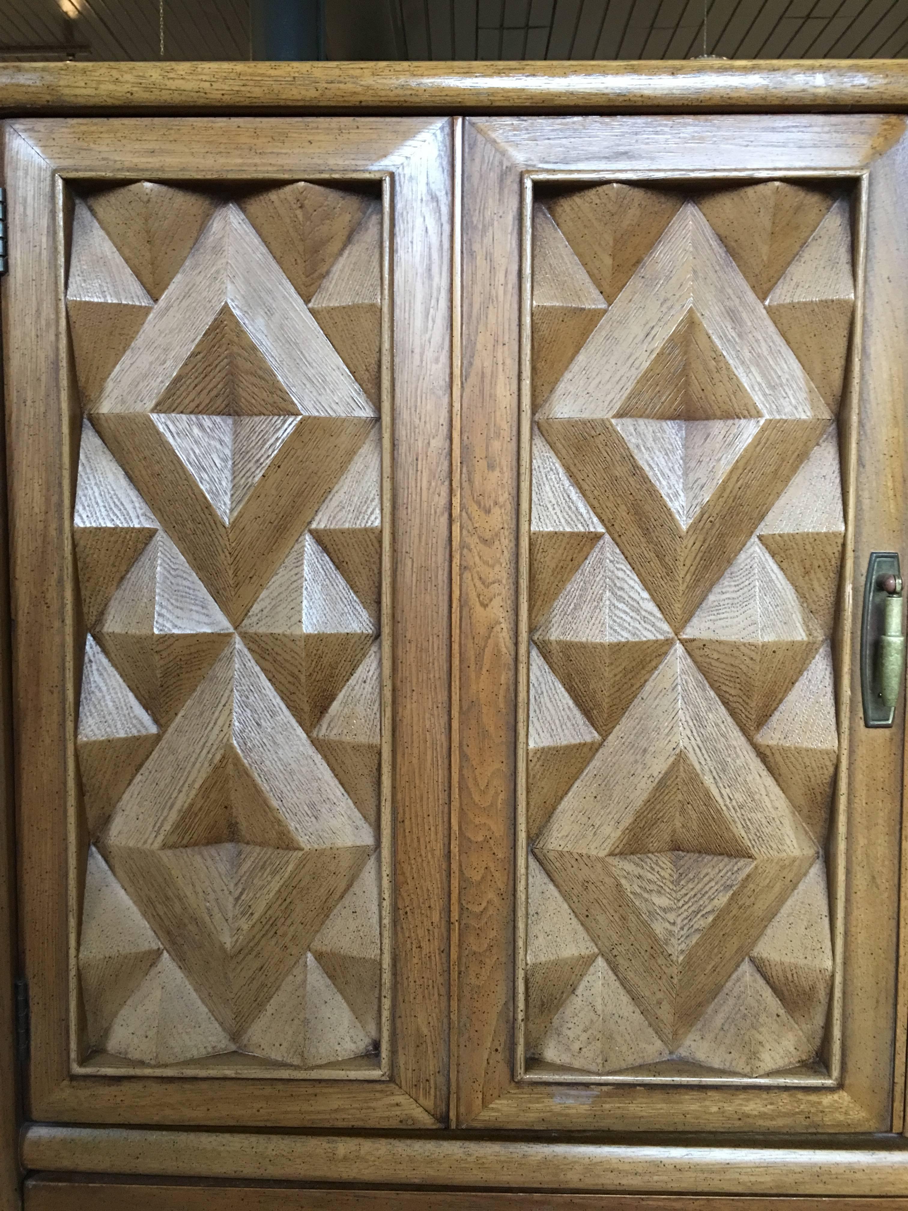 Mid-Century Modern Diamond Head armoire cabinet by Broyhill Premier. Beautiful and sculptural, this case piece features a unique geometric cubist pattern in natural pecan tones and original brass hardware. This brutalist style chest can be used as a