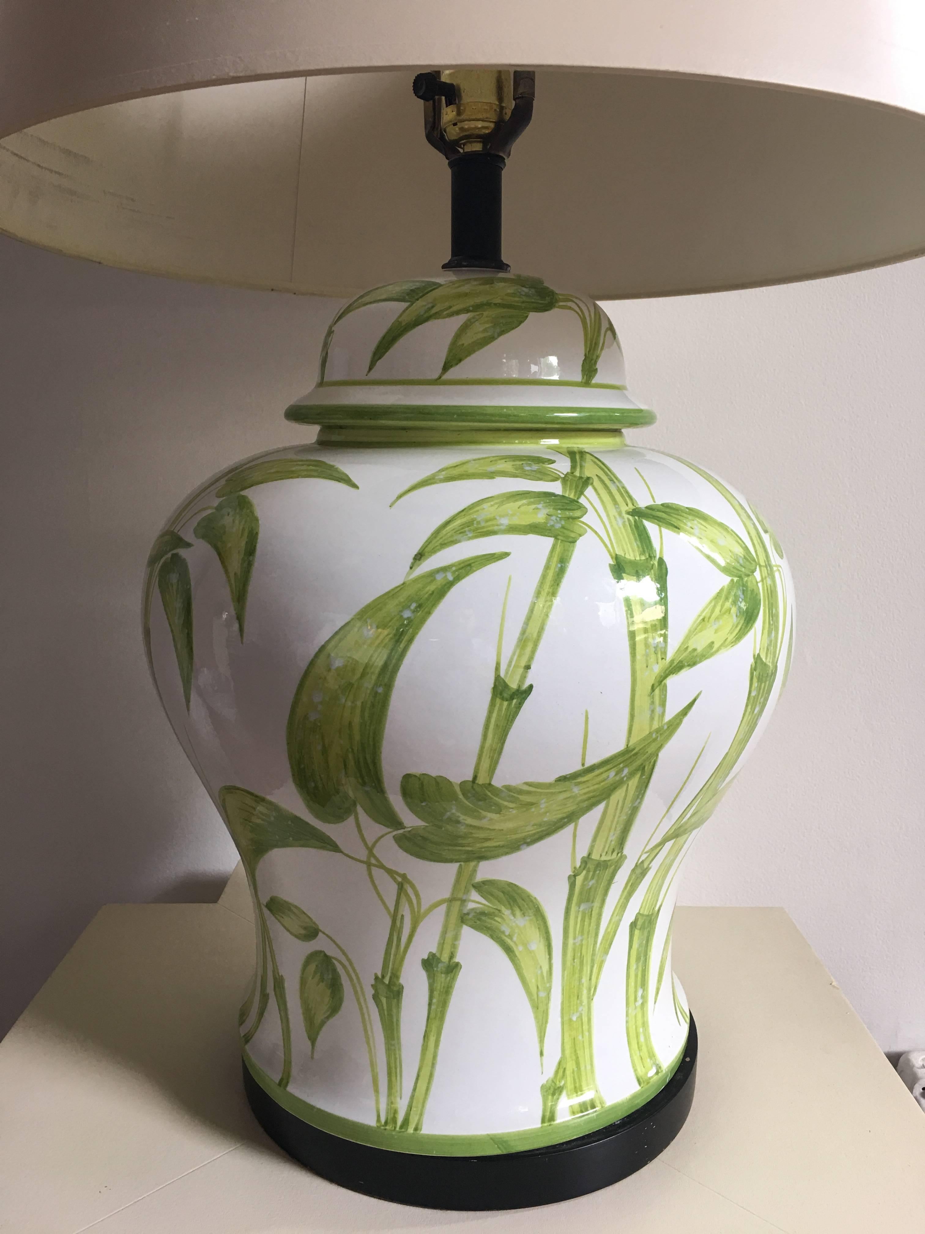 Mid-Century Modern Hollywood Regency style ceramic ginger jar table lamp with hand-painted bamboo leaf or botanical motif over a gloss white glaze. This Palm Regency Style lamp is marked 