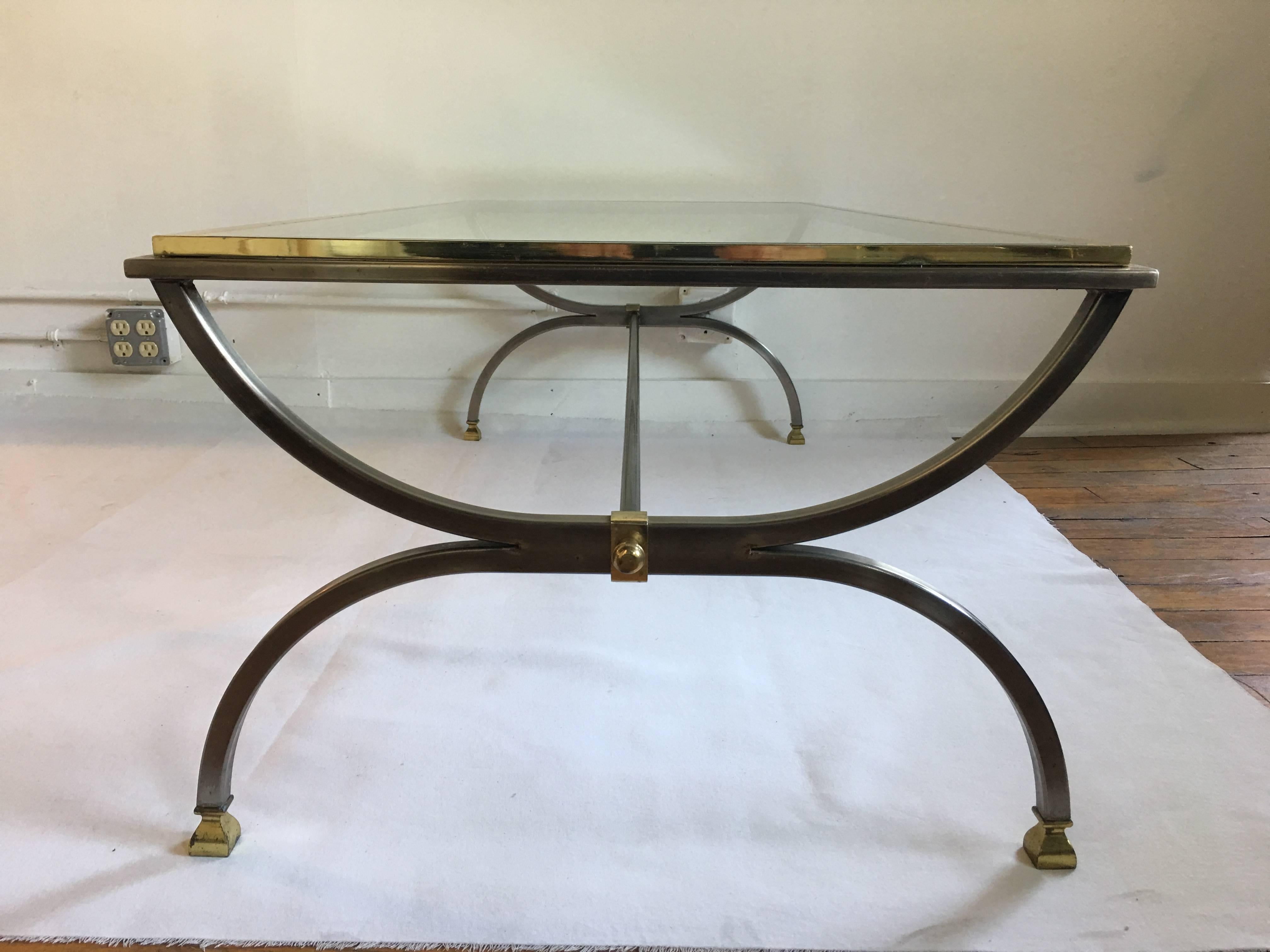 Large midcentury brass and chrome rectangle shaped cocktail table with a removable clear glass top. Curved/arched legs feature a center stretcher rod support and square capped footed legs.