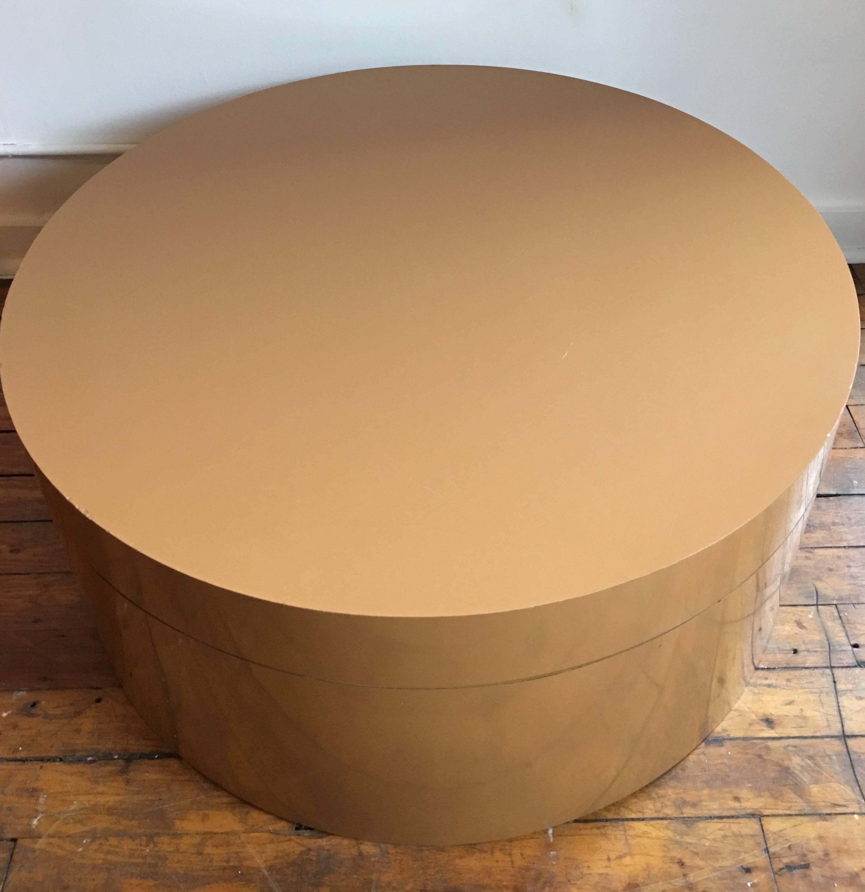 Large round Mid-Century Modern two-tier swivel cocktail table. Top tier can be expanded to reveal two circular tops or remain stacked in a single cylinder/drum shape. Original orange tone wrapped laminate.

Bottom tier measures 12 inches