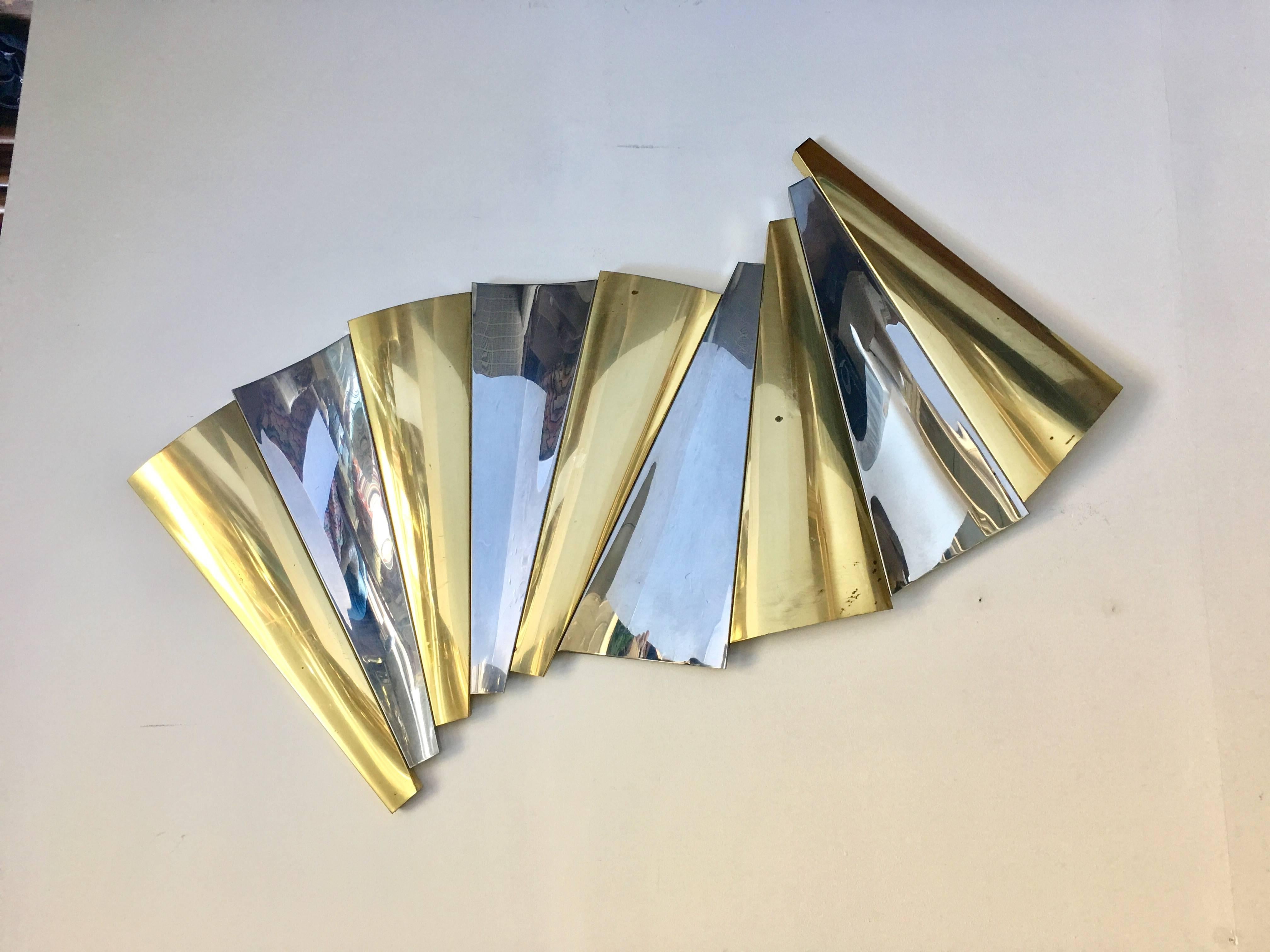 Modern brass and chrome wall sculpture by Curtis Jere. This mixed metal abstract art sculpture features a curved fan-like design. Can be hung in multiple ways or angles. Signature no longer visible due to cleaning.