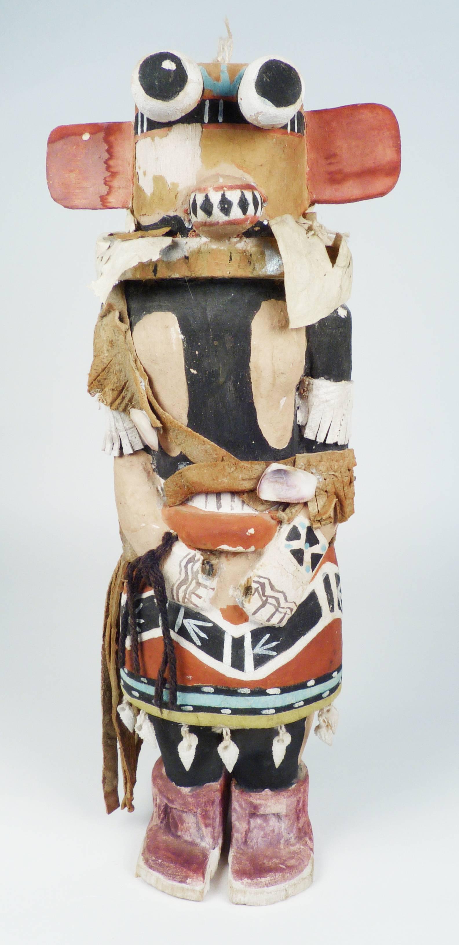 This is a traditional Hopi kachina doll carved from a single piece of cotton wood root representing the Hote Kachina.  Wonderfully detailed regalia including the snake dance kilt, hide bandolier bag, painted ketoh and body paint bring life to this