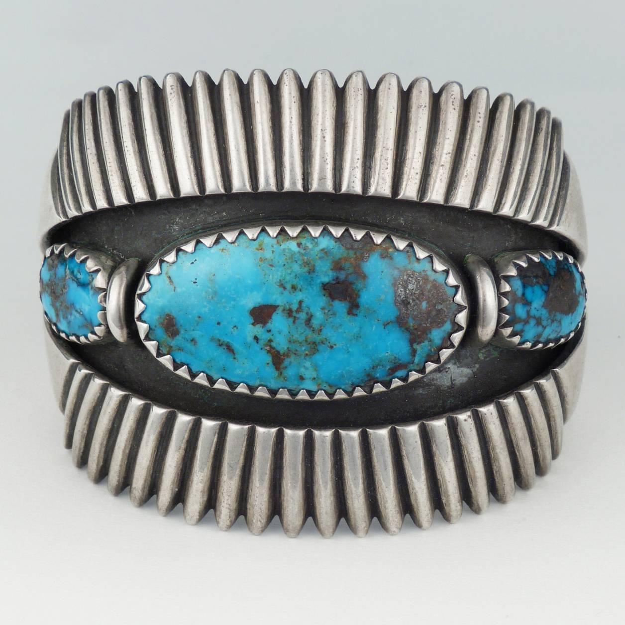 An exquisite handmade bracelet from the father of modern Navajo jewelry, Kenneth Begay (1913-1977). Three hand sawn bezels encircle gem quality Morenci turquoise cabochons. Hand-chiseled ridges surround a shadowbox.