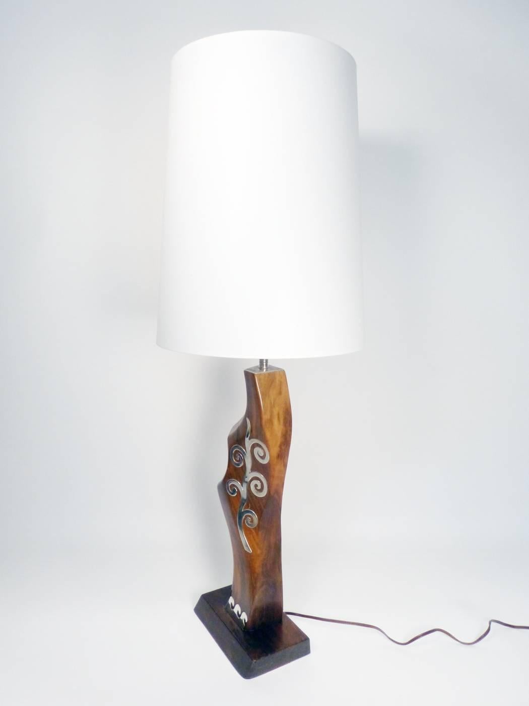 A wonderful example of Navajo modernism, this lamp was made in the 1960s, most likely by master silversmith Kenneth Begay. Lovely organic wood form and sterling silver overlay decoration.
Measures: 35 1/2