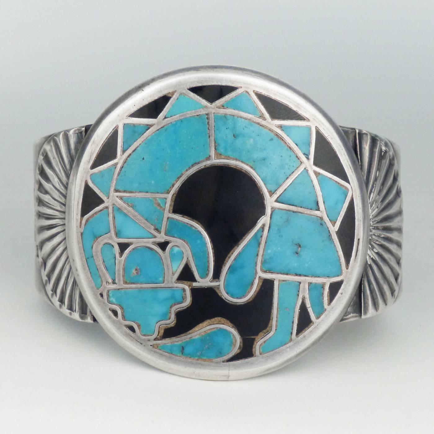 An exquisite example of mid-20th Century Zuni inlay, this set features a cuff, a brooch, screw-back earrings and a ring. Unsigned, but attributed to Zuni inlay master Dan Simplicio. Made during at the high point of Zuni inlay at the trading post