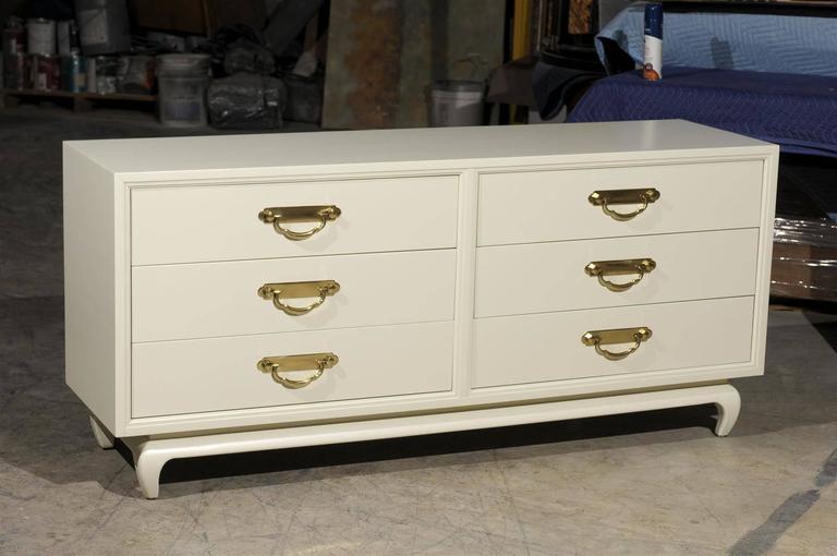 An exquisite example from a rare series by American of Martinsville, circa 1960. Stout, expertly made mahogany case construction restored in cream lacquer. Fabulous, chunky solid brass hardware mark the drawers. An elegant and sophisticated piece