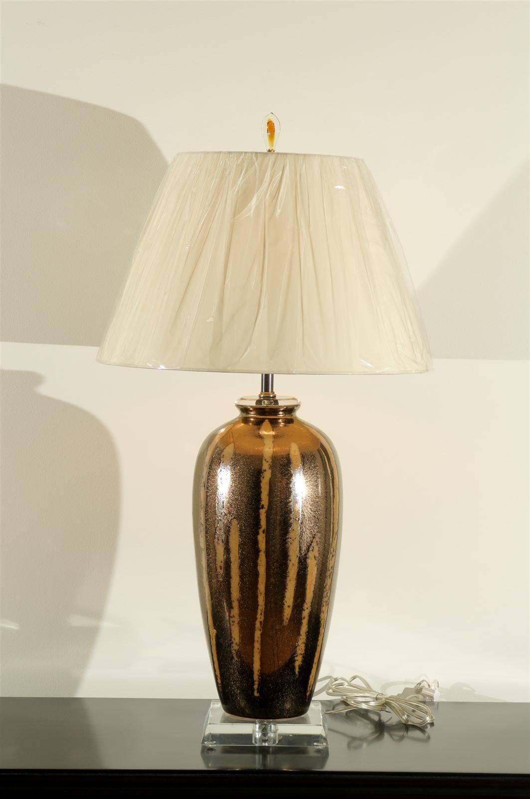 An exceptional pair of large-scale vessels as lamps. Ceramic in copper and bronze tones with an almost metallic glazed finish. Dramatic pieces that are both modern and warm. Exquisite jewelry! Excellent restored condition. Wired using clear cord;