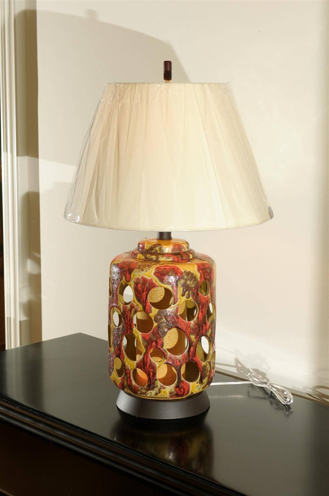 Une incroyable paire de lampes vintage en céramique percée. Finition glacée au goutte à goutte en ocre jaune, caramel et paprika. L'élément d'éclairage original en lin de couleur ocre est intact. L'interrupteur à trois positions permet d'allumer