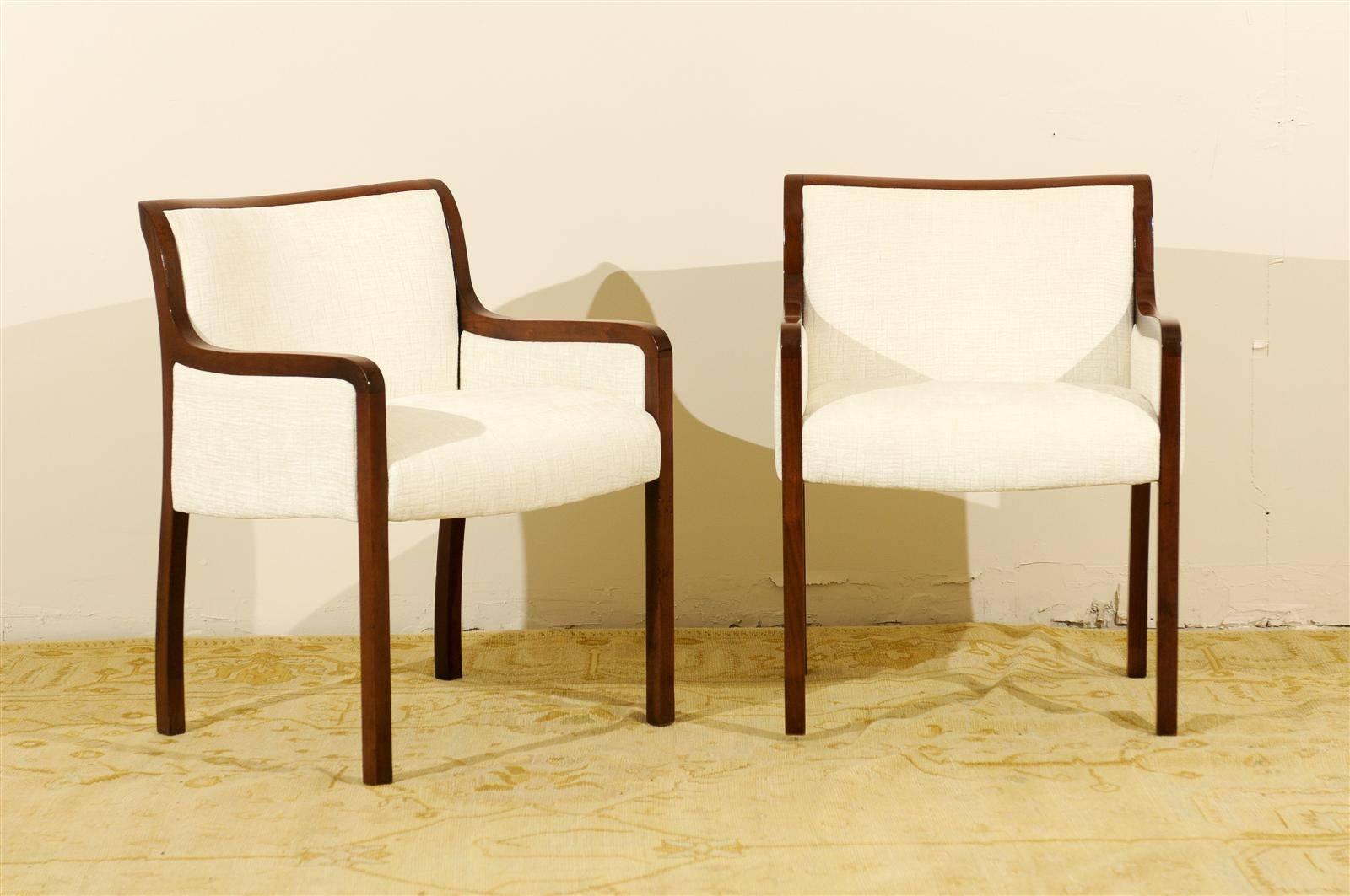 An exceptional pair of modern occasional chairs. Stout walnut construction highlighted by a fabulous rear leg and back detail. Beautifully made and wonderfully comfortable. While the pieces are unmarked, the design and craftsmanship are consistent