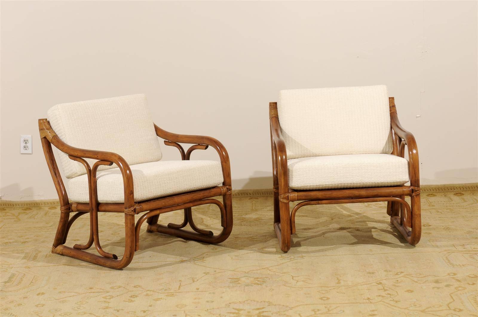 An exceptional pair of vintage loungers, circa 1970. Decorative, stout Modern rattan frame with a beautiful seat and back detail in raffia. A comfortable and compact design. Dramatic pieces that do not demand a great deal of floor area. Excellent